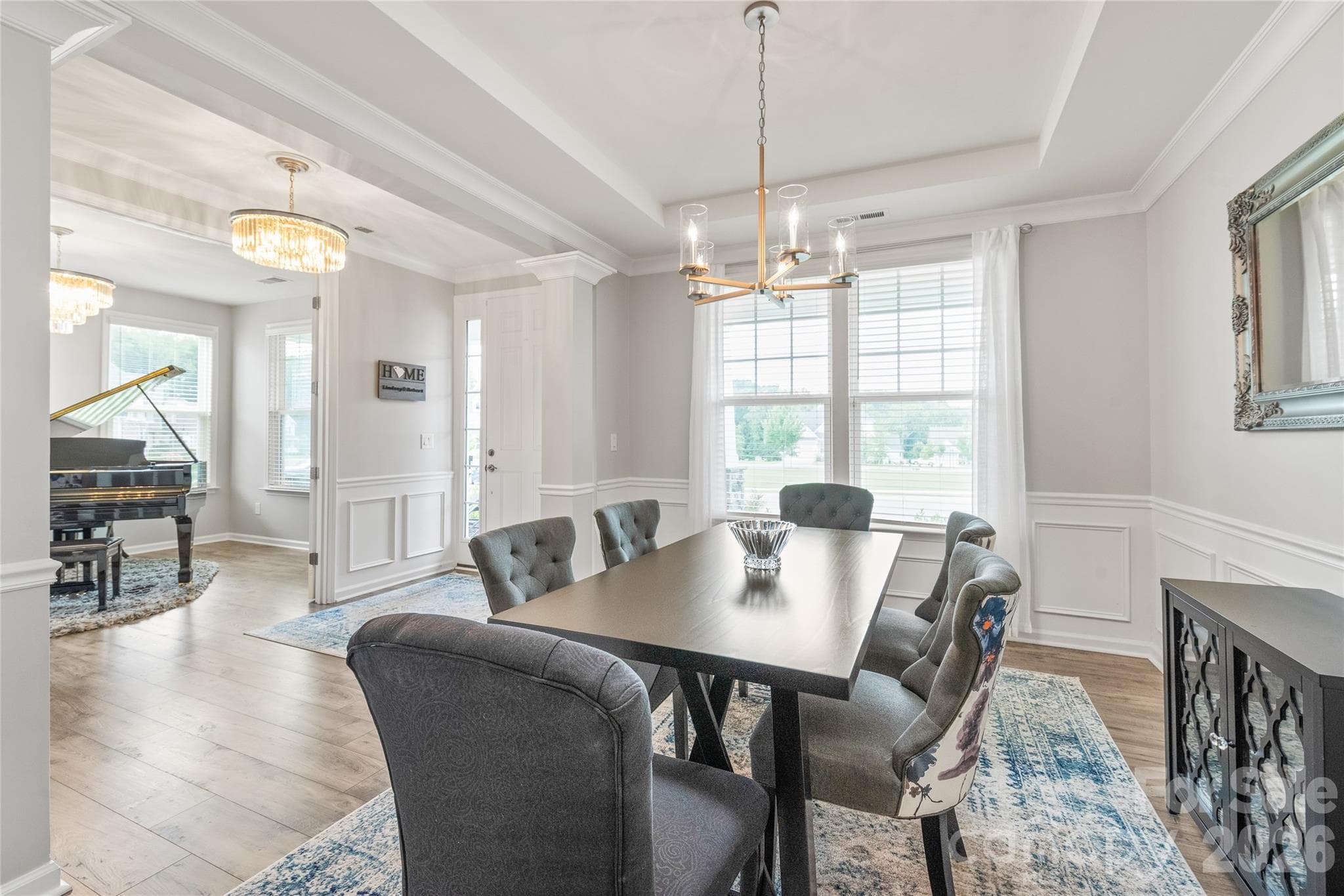 Across the hall, the elegant dining room features refined trey ceilings, detailed trimwork, and seamless LVP floors designed for memorable dinners and effortless hosting. - 6440 Ancient Way, Fort Mill
