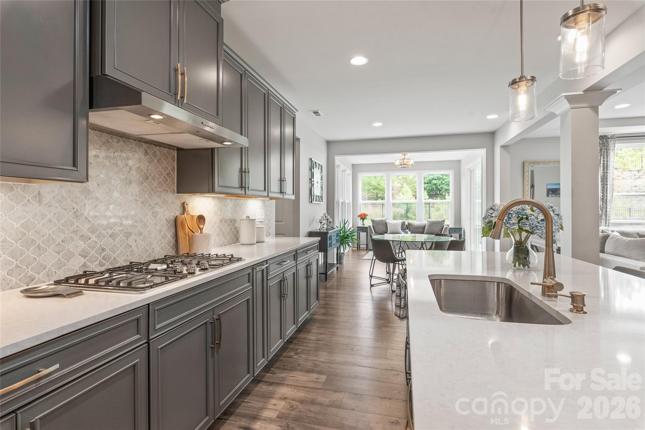 Designed for culinary precision and easy cleanup, the kitchen features a high-performance 5-burner gas cooktop and a sleek, deep single-basin undermount sink. - 6440 Ancient Way, Fort Mill