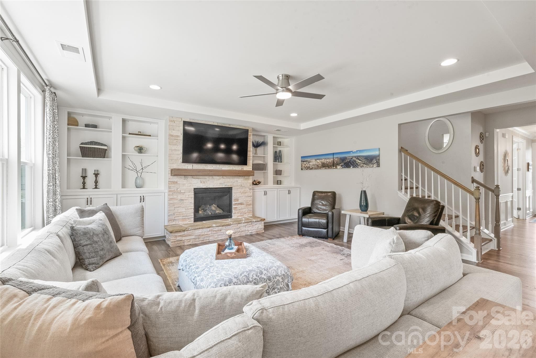 Highlighted by an elegant trey ceiling with soft recessed lighting, the living room offers an elevated, atmospheric setting for relaxed evenings and effortless entertaining. - 6440 Ancient Way, Fort Mill