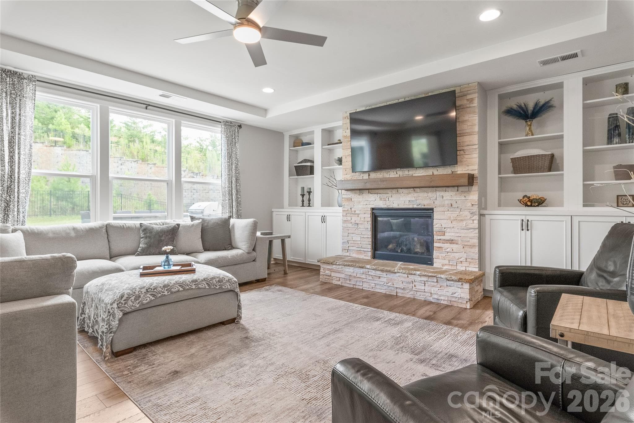 Flooded with natural light, the living room features expansive windows that highlight the beauty and continuity of the LVP floors. - 6440 Ancient Way, Fort Mill