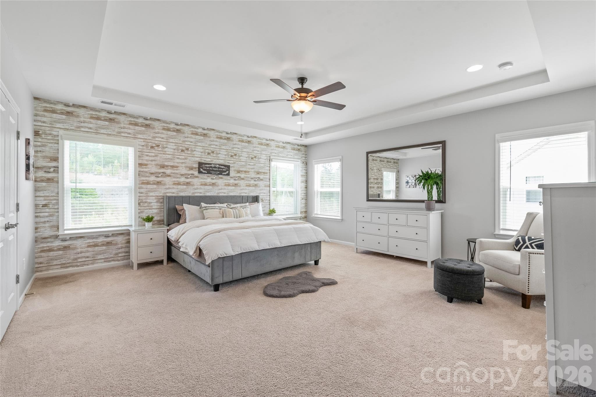 A serene private retreat, the spacious primary bedroom boasts elegant trey ceilings and a luxurious attached ensuite. - 6440 Ancient Way, Fort Mill