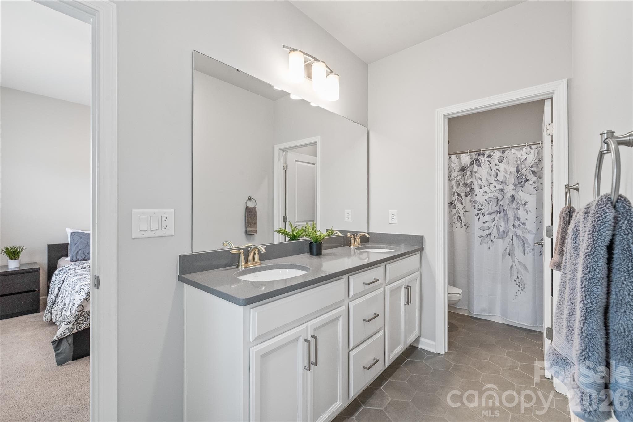 Perfectly designed for shared living, this Jack-and-Jill bathroom features dual sinks and a separate wet room with the tub and toilet...making busy morning routines seamless for Bedrooms 3 and 4. - 6440 Ancient Way, Fort Mill