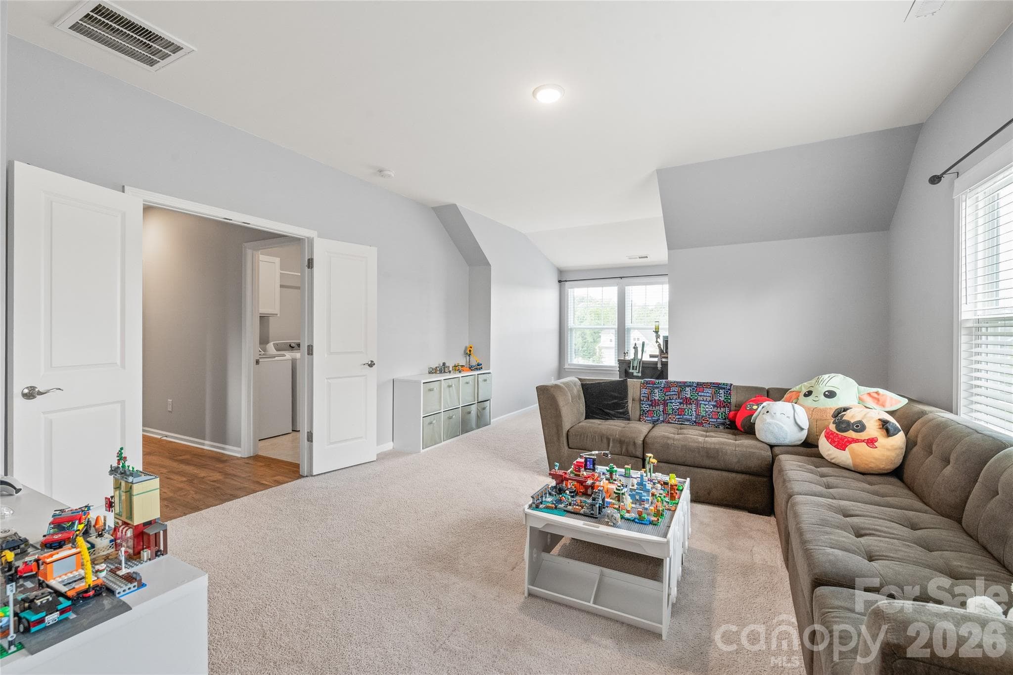 Framed by double doors, this spacious bonus room offers a versatile space perfect for a home theater, play area, or lounge. - 6440 Ancient Way, Fort Mill