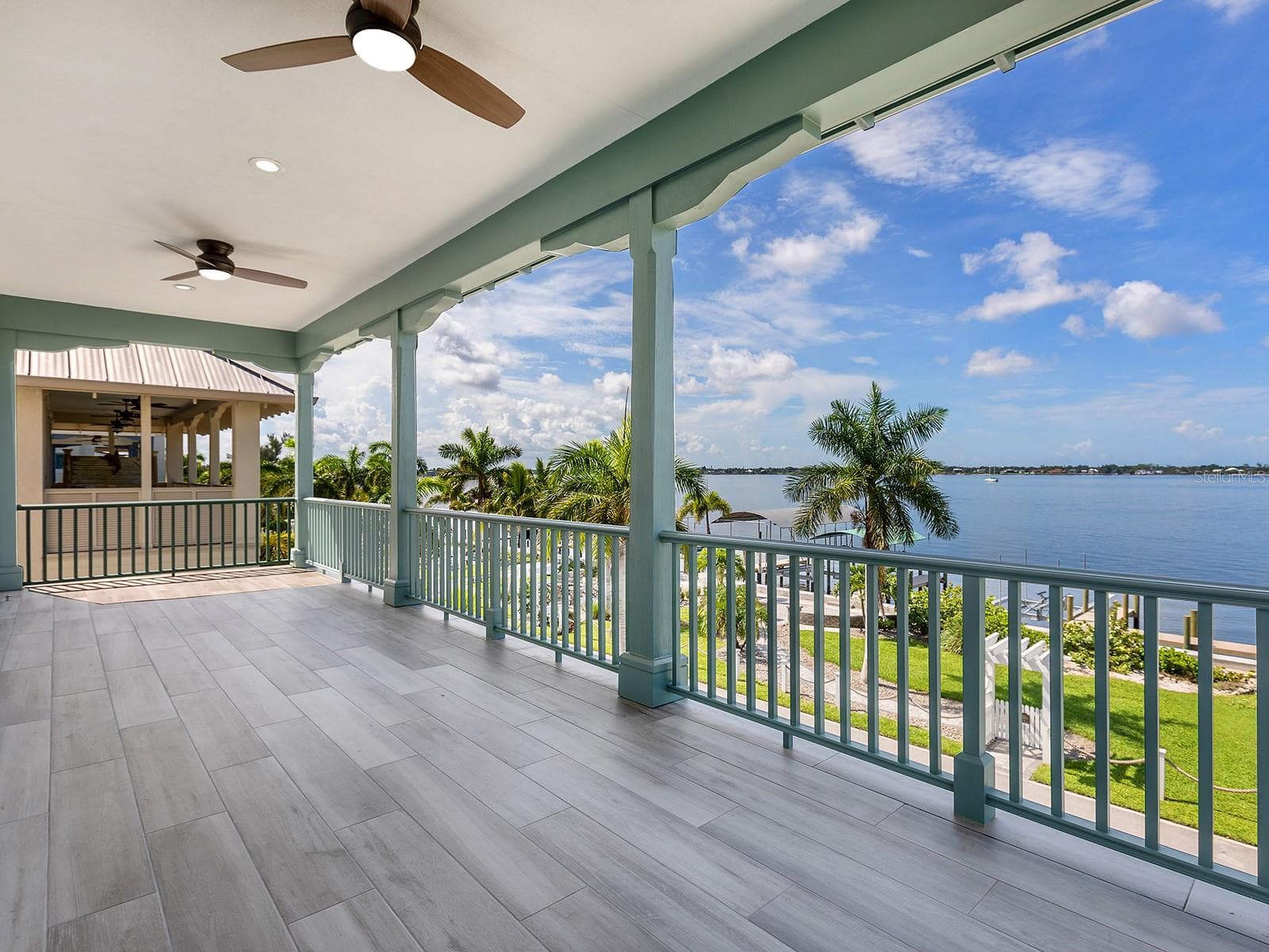 Second floor covered balcony offering sweeping water views, ceiling fans, and tiled flooring designed for outdoor living - 4024 11TH STREET CT W, PALMETTO