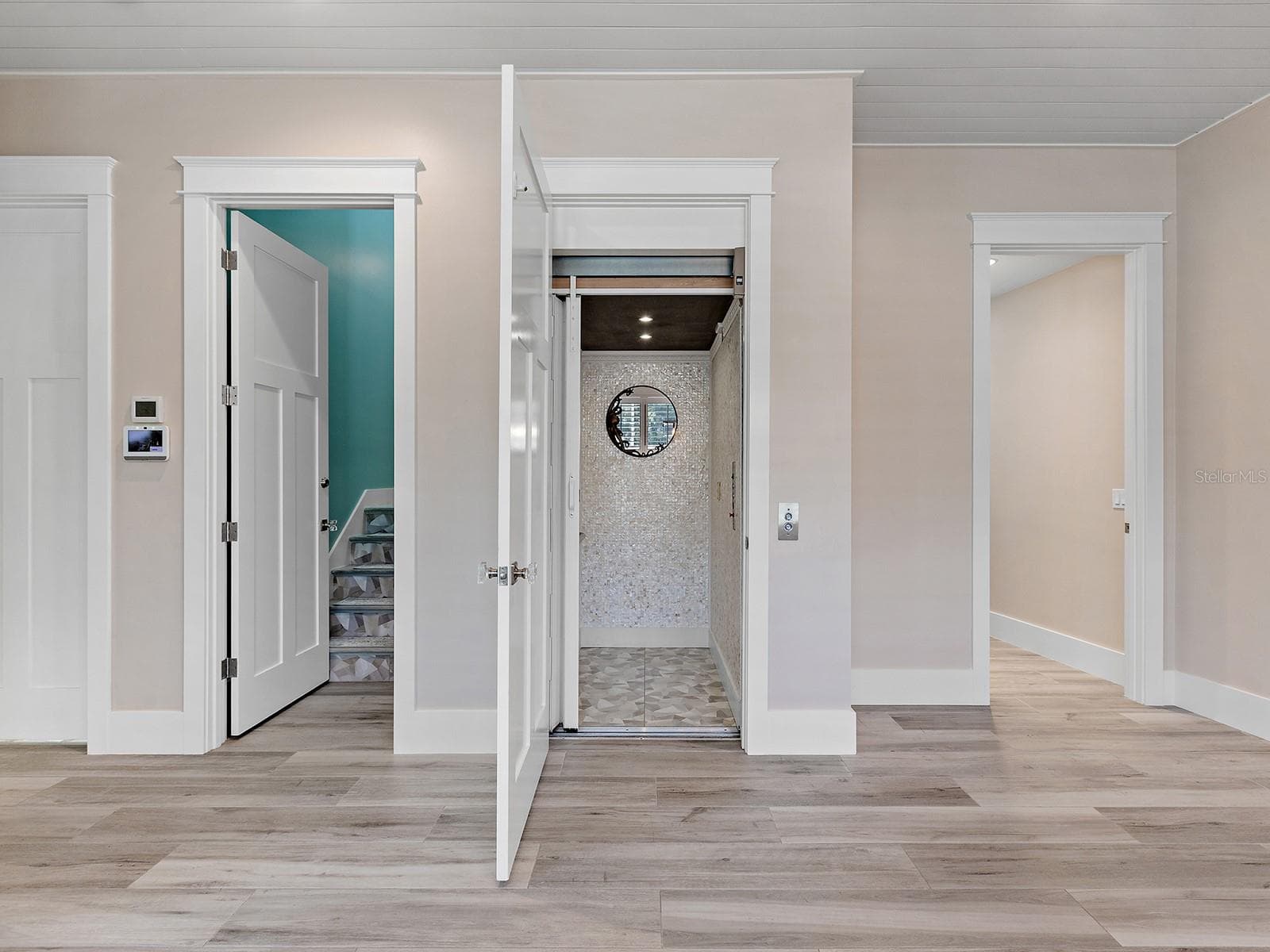 Tiled, accessible elevator next to a staircase to the second floor - 4024 11TH STREET CT W, PALMETTO