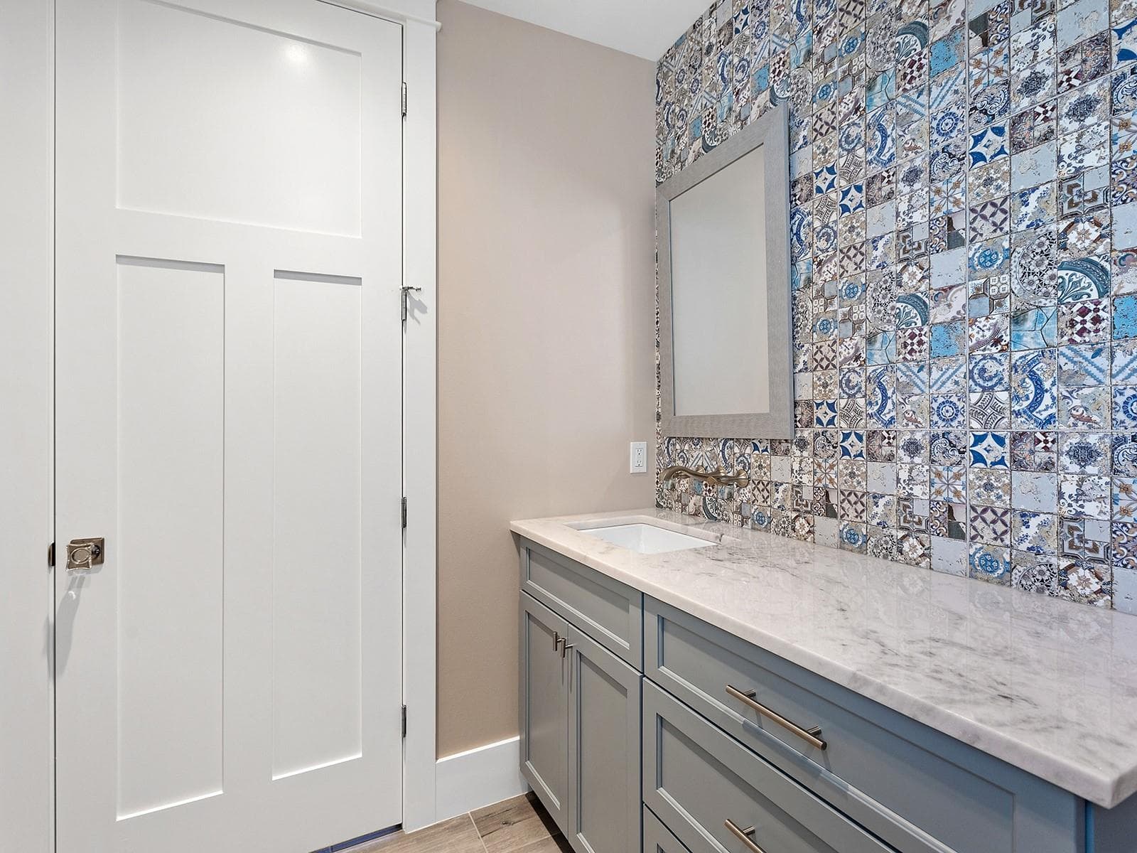 Half bath on the ground floor. Mediterranean-inspired mosaic tile feature wall, brushed gold wall-mounted hardware, and light quartz countertops - 4024 11TH STREET CT W, PALMETTO