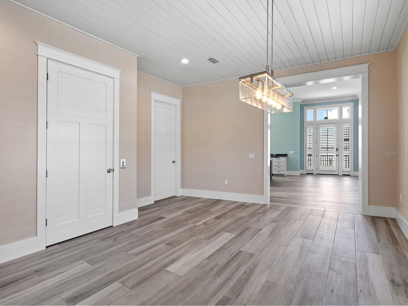 Ground-floor dining area between the pool deck and front door featuring elevator access, a half bath, and seamless flow to the laundry room and primary suite with two closets - 4024 11TH STREET CT W, PALMETTO