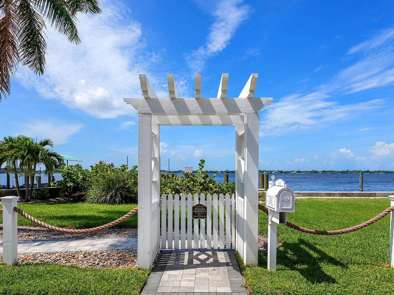 Arbor across the road from the home brings you to a paver terrace and a new 38-foot deeded dock with a boat lift beside a a brand-new, elevated seawall - 4024 11TH STREET CT W, PALMETTO