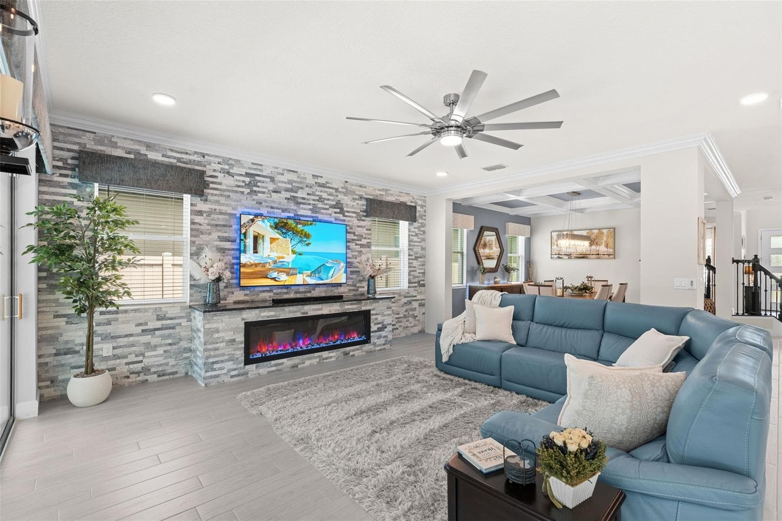 Spacious open living room with a stacked stone feature wall that includes an electric fireplace. - 3336 LONE CYPRESS PT, OVIEDO