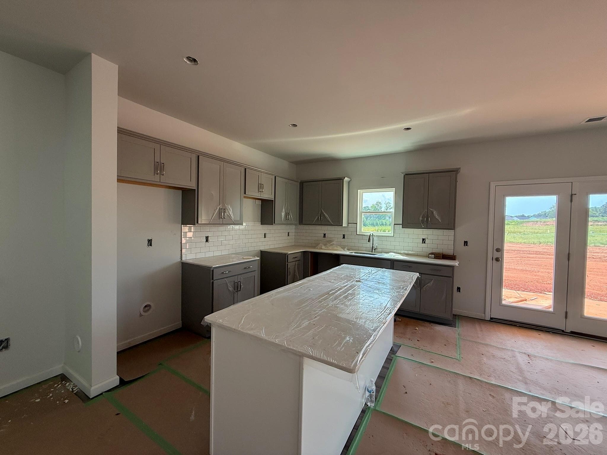 Kitchen features Gray Surround cabinets and White Island with Quartz countertops - Charlotte