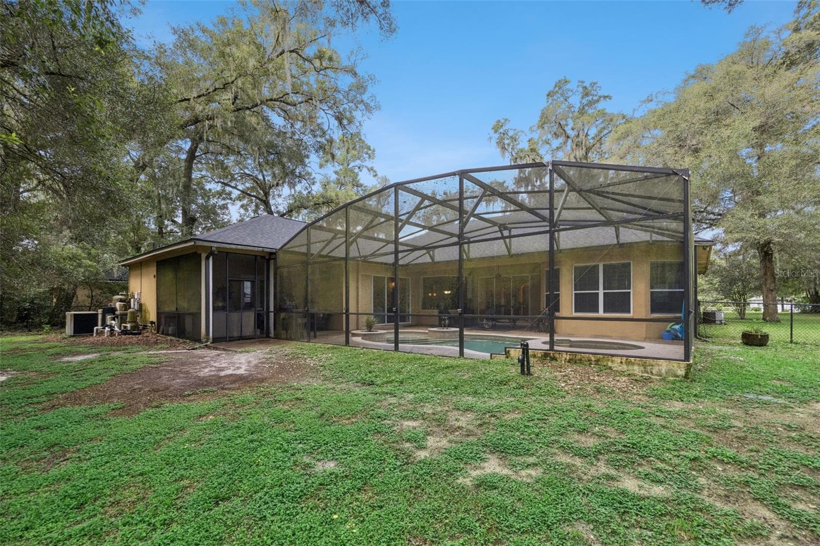 Rear exterior view shows the scale of the screened pool enclosure and backyard. - 30440 JUBILEE WAY, SORRENTO