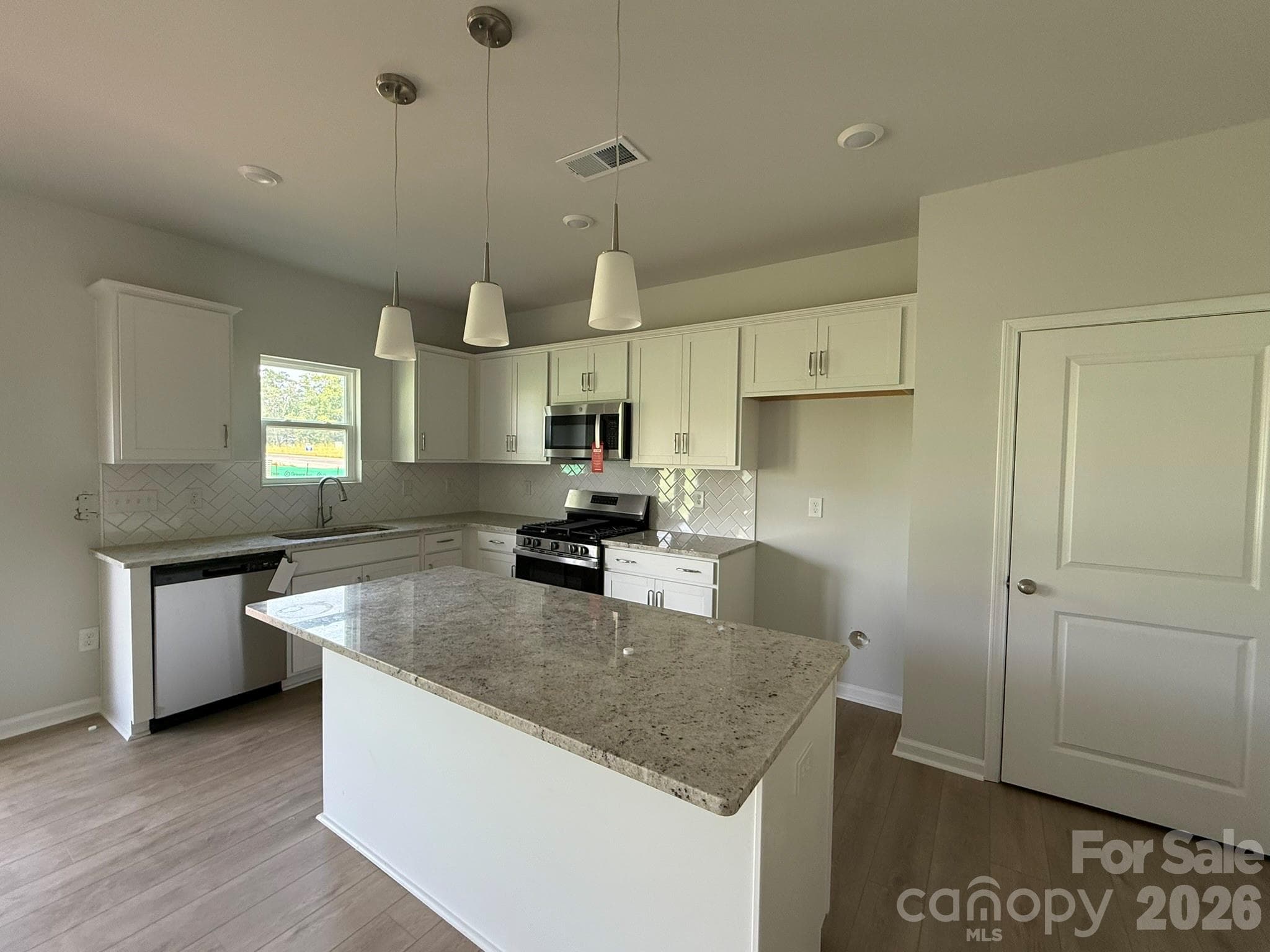The Kitchen features white cabinets and granite countertops - 1305 Bansal Drive, Charlotte