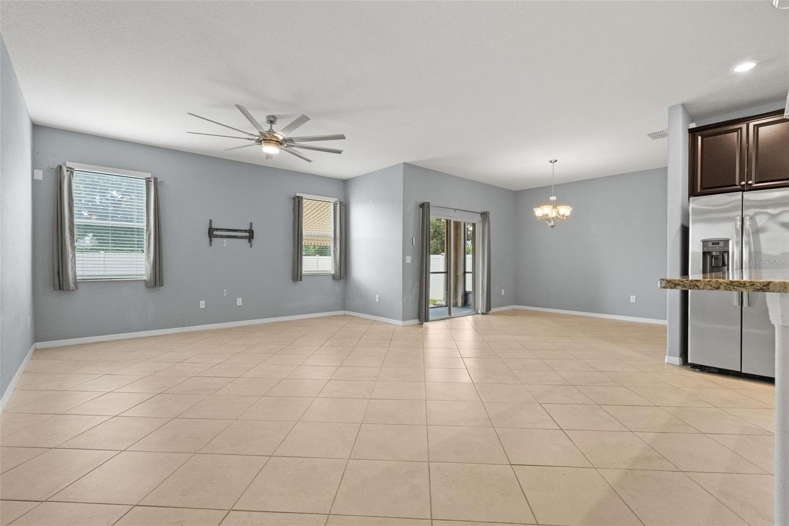 Living Area — Spacious main living area with tile flooring, abundant natural light, and direct access to the screened lanai. - 13728 REINDEER CIR, HUDSON