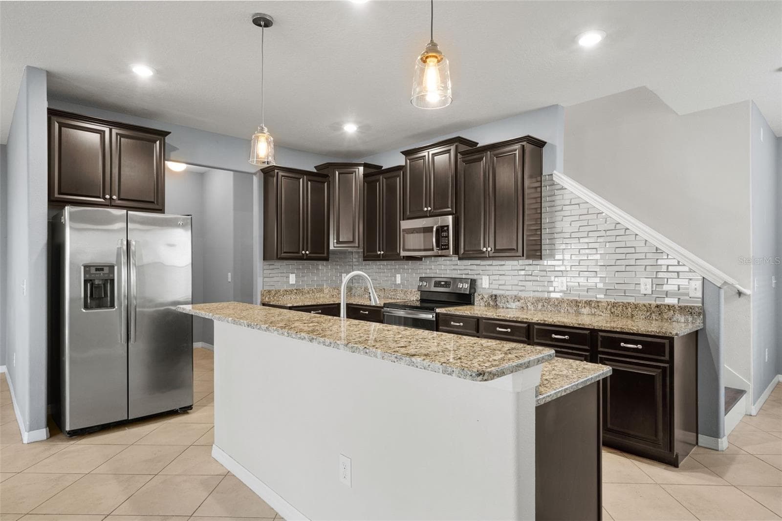 Kitchen — Generous breakfast bar provides additional countertop space and casual seating while connecting the kitchen to the living area. - 13728 REINDEER CIR, HUDSON
