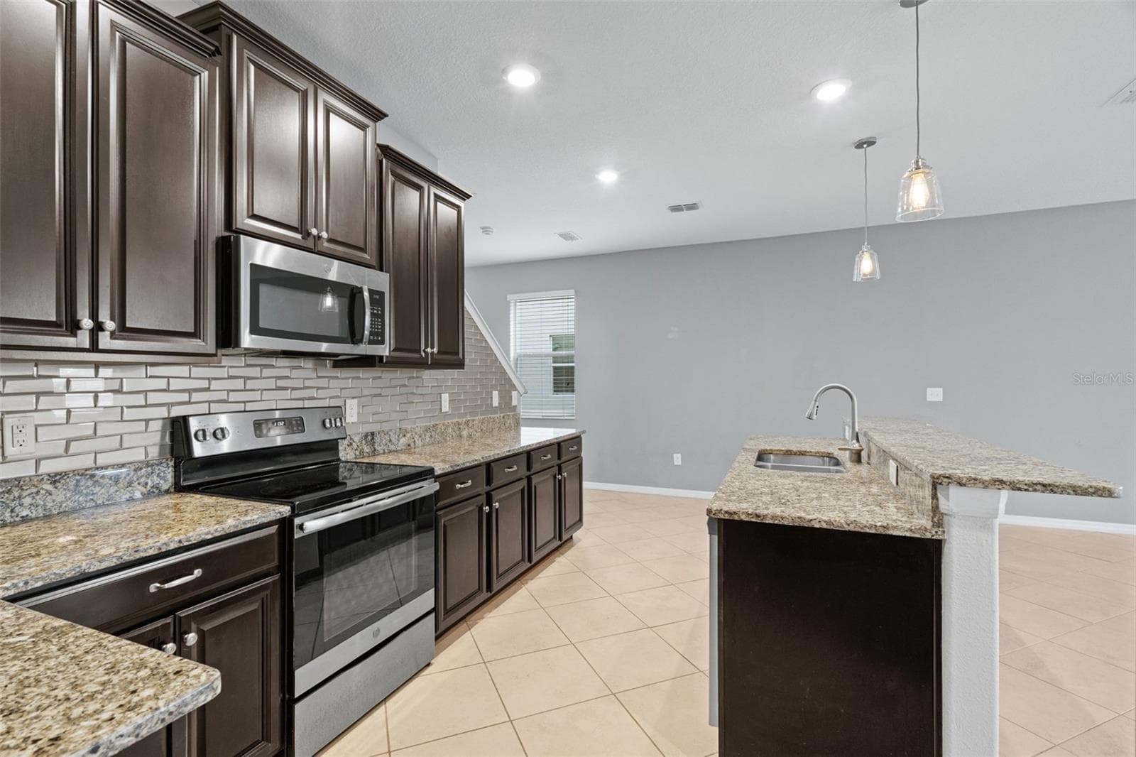 Kitchen & Living Area — Kitchen opens directly to the main living space, providing an easy flow for entertaining and everyday living. - 13728 REINDEER CIR, HUDSON