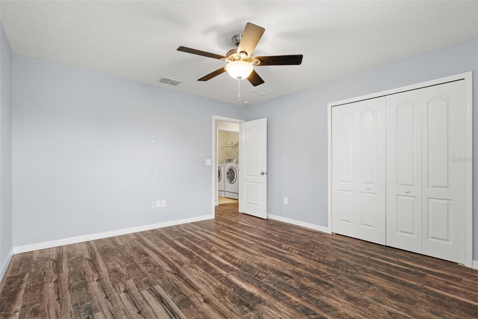Bedroom – Additional view of the bedroom showcasing generous floor space, double-door closet, and convenient access to the laundry area. - 13728 REINDEER CIR, HUDSON