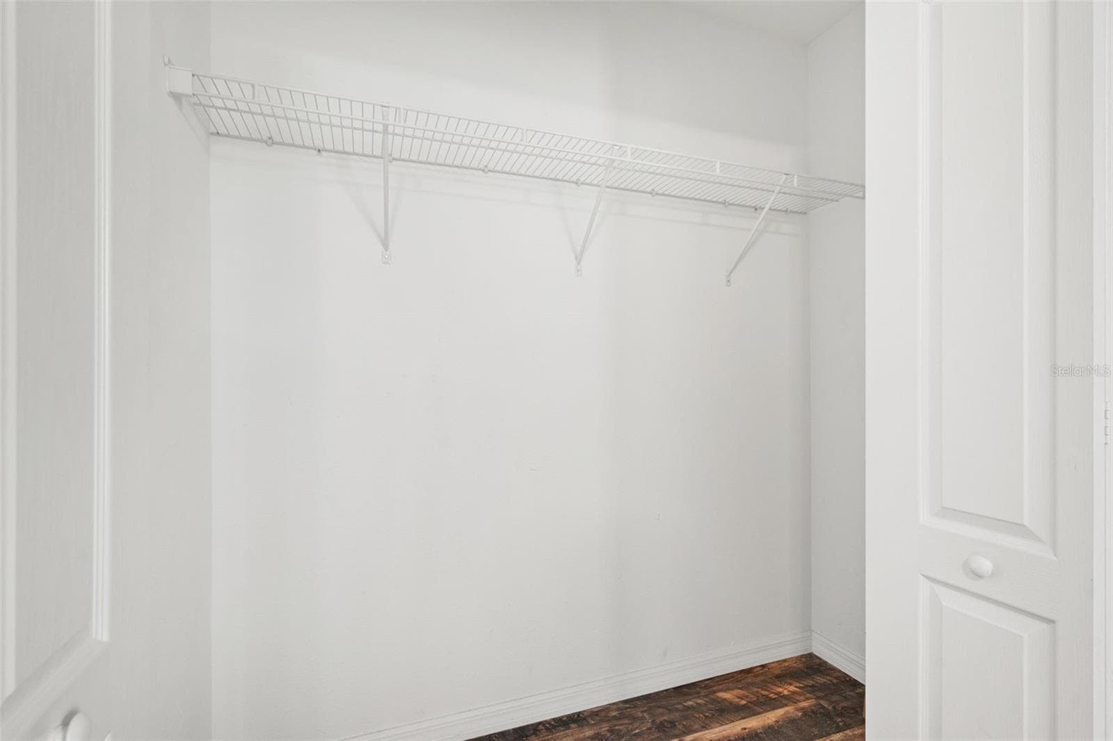Bedroom Closet – Spacious bedroom closet with built-in wire shelving and wood-look flooring. - 13728 REINDEER CIR, HUDSON