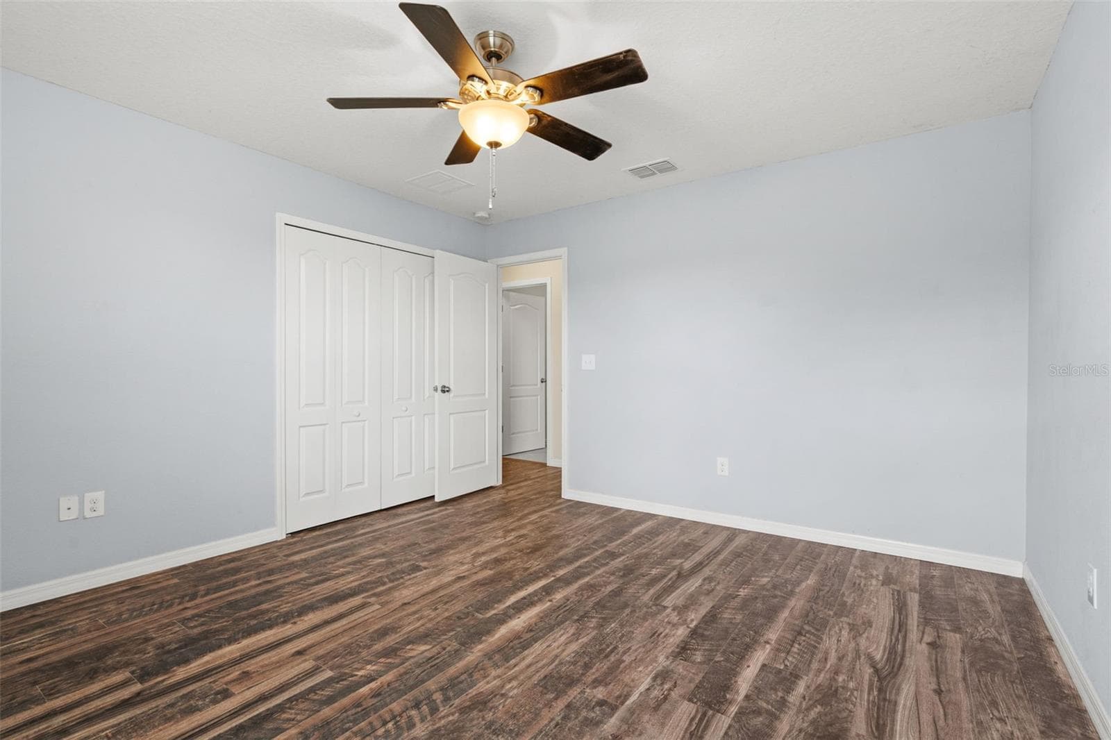 Bedroom – Additional angle showcasing the bedroom’s closet, ceiling fan, and generous floor space. - 13728 REINDEER CIR, HUDSON