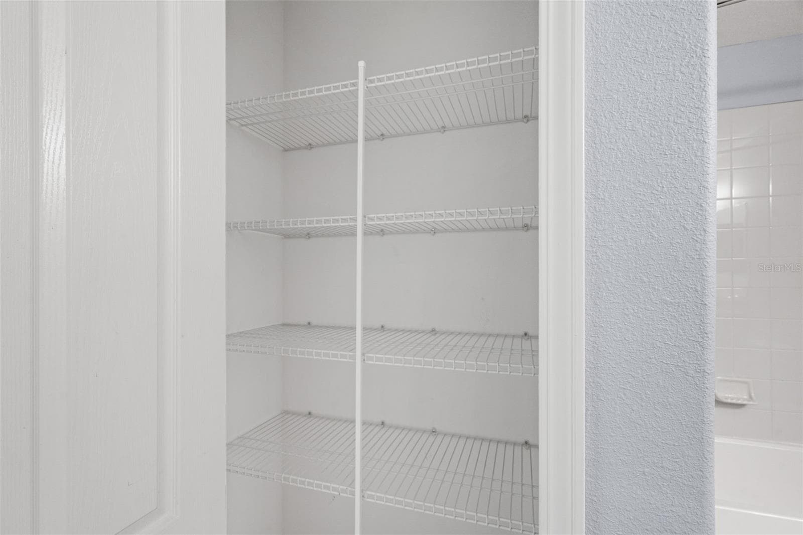 Bathroom Storage – Convenient built-in linen closet with multiple shelves located near the bathroom. - 13728 REINDEER CIR, HUDSON