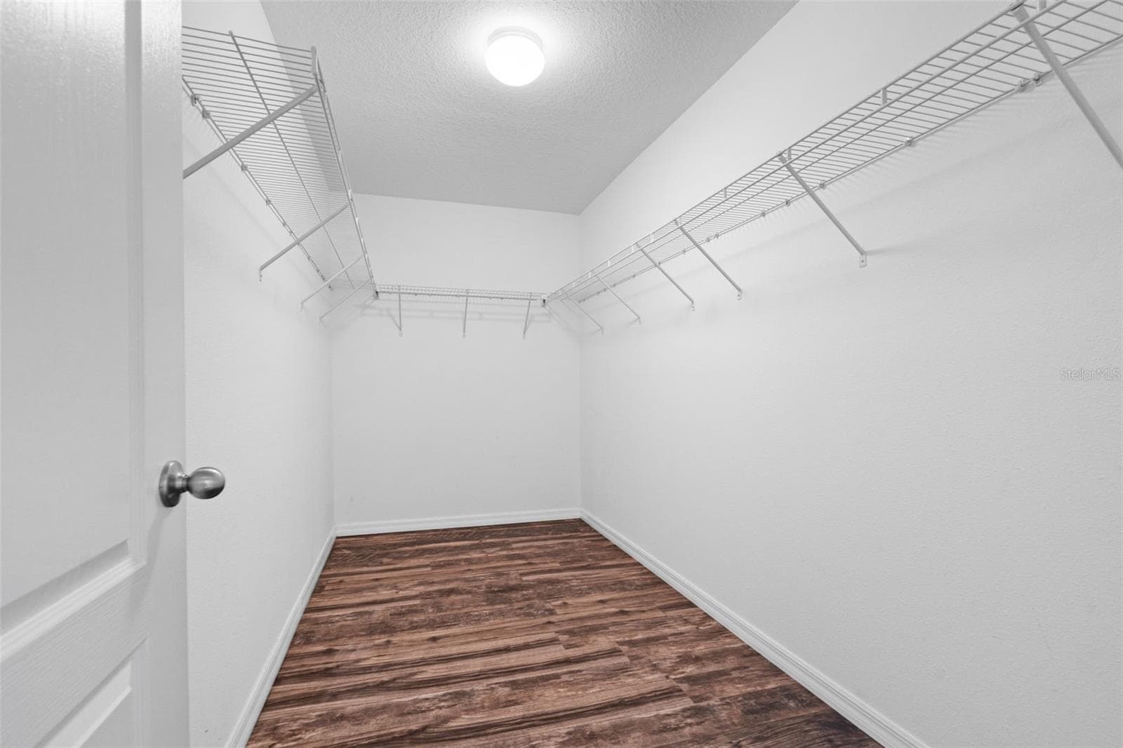 Walk-In Closet – Large walk-in closet featuring wraparound wire shelving and ample storage space. - 13728 REINDEER CIR, HUDSON