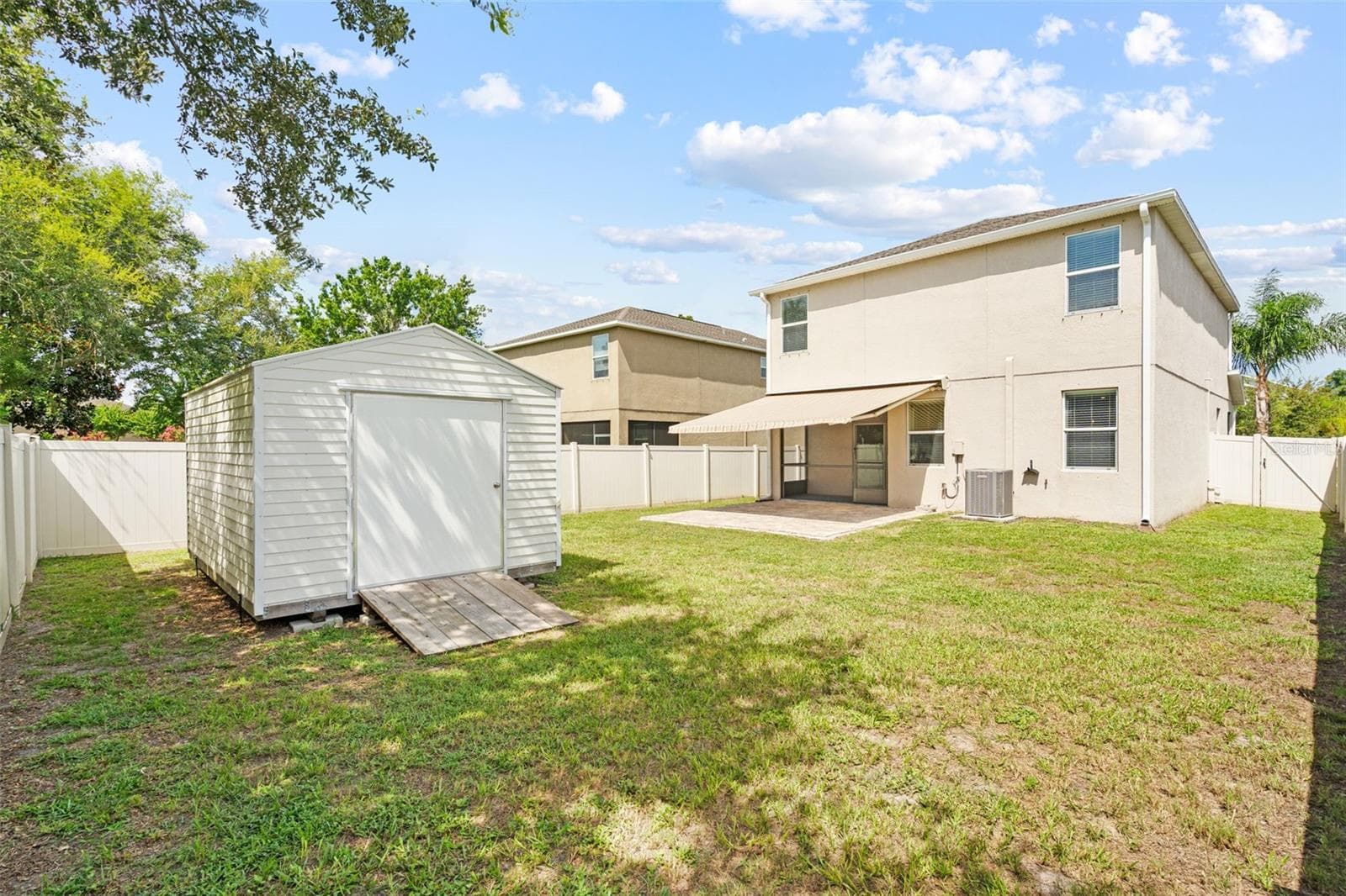 Backyard – Fully fenced backyard with storage shed, screened patio, and plenty of open outdoor space. - 13728 REINDEER CIR, HUDSON