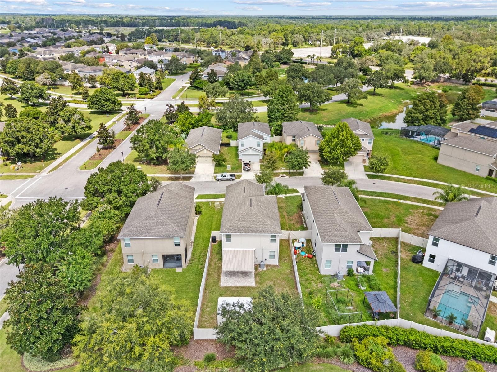 Rear Aerial View – Elevated rear view showcasing the homesite, fenced backyard, and surrounding community. - 13728 REINDEER CIR, HUDSON