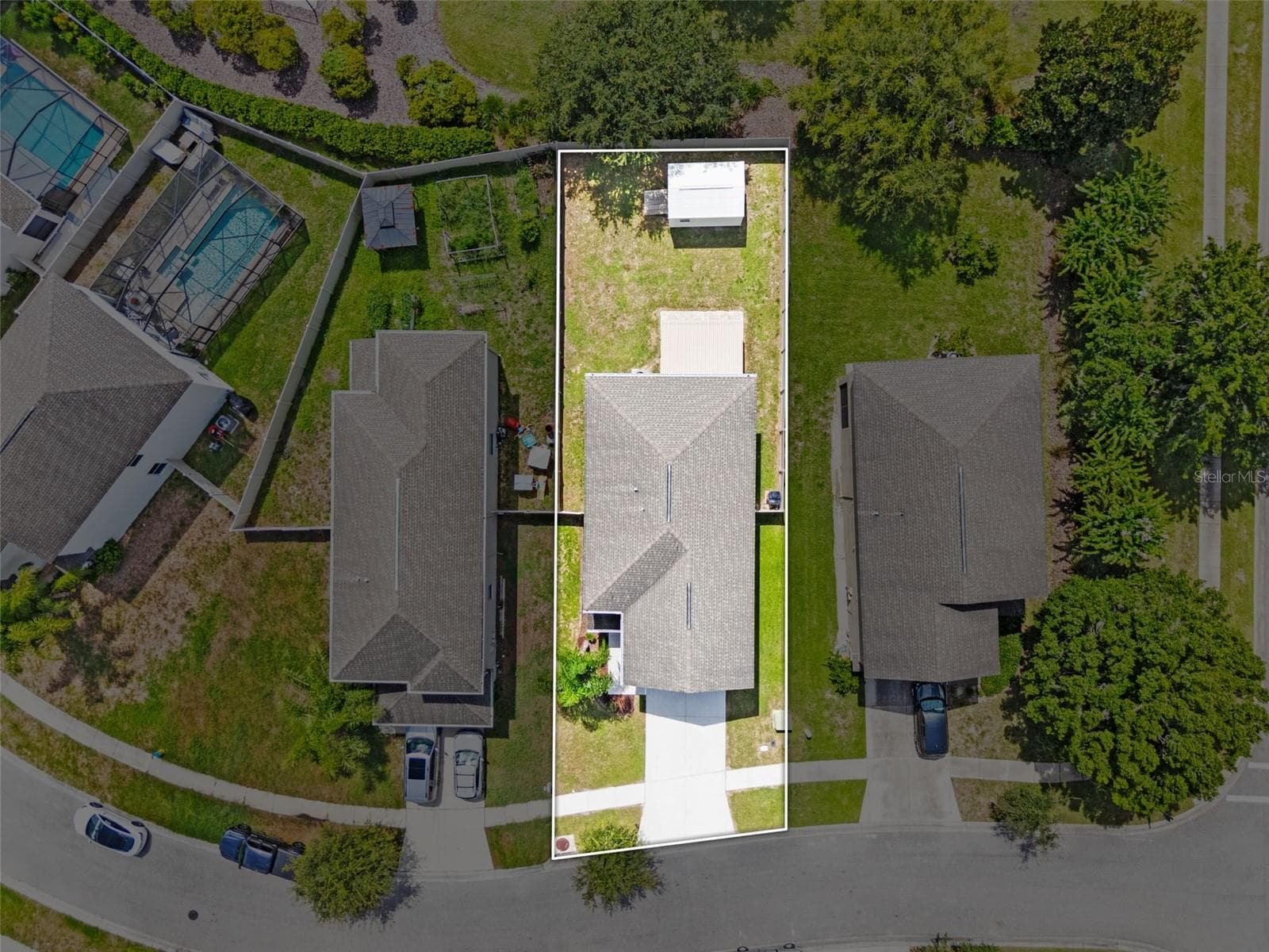 Aerial Lot View – Overhead aerial with property boundaries highlighted to show the homesite and backyard. - 13728 REINDEER CIR, HUDSON