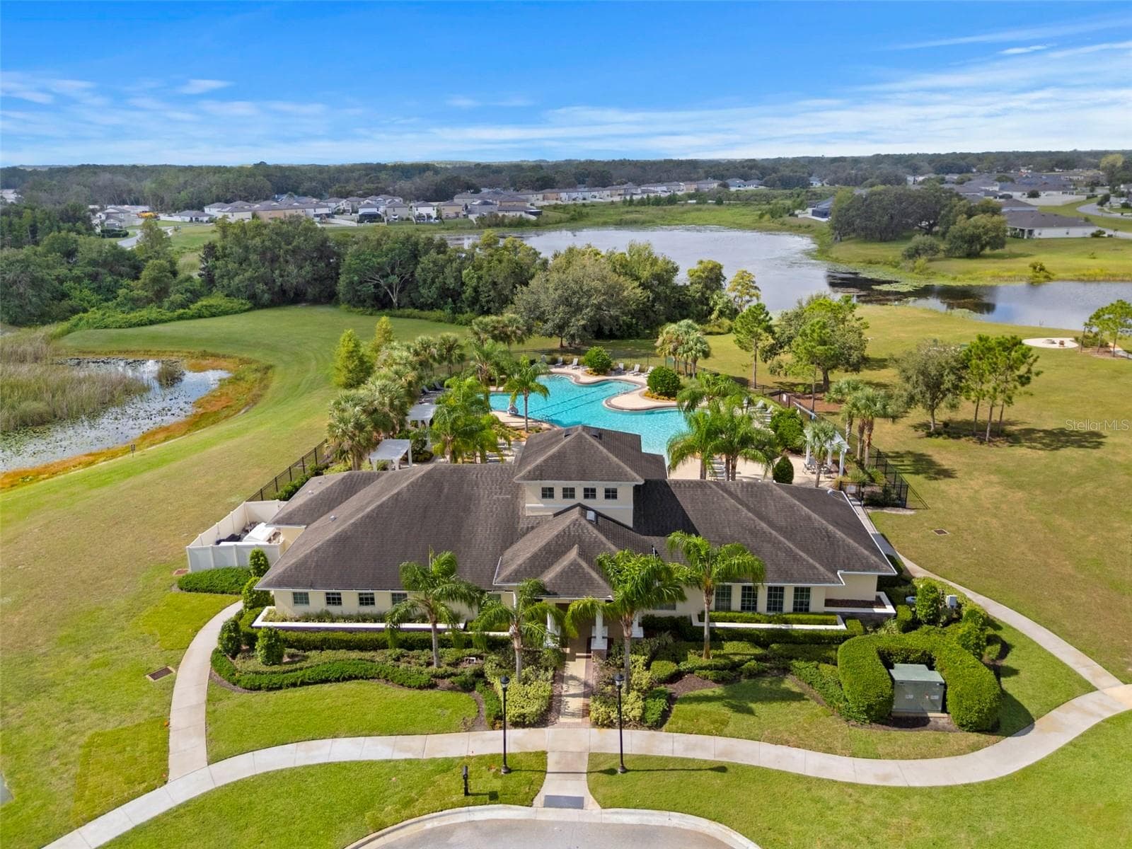 Community Clubhouse & Pool – Aerial view of the Lakeside community clubhouse, resort-style swimming pool, and surrounding lake views. - 13728 REINDEER CIR, HUDSON
