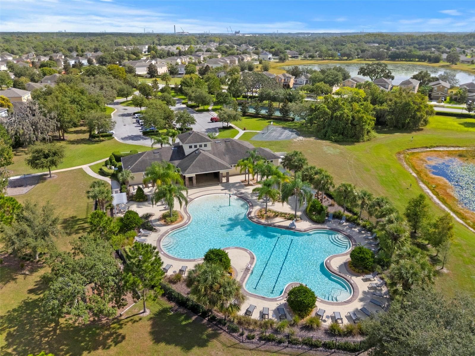 Community Pool – Aerial view of the spacious resort-style community pool surrounded by tropical landscaping and lounge areas. - 13728 REINDEER CIR, HUDSON