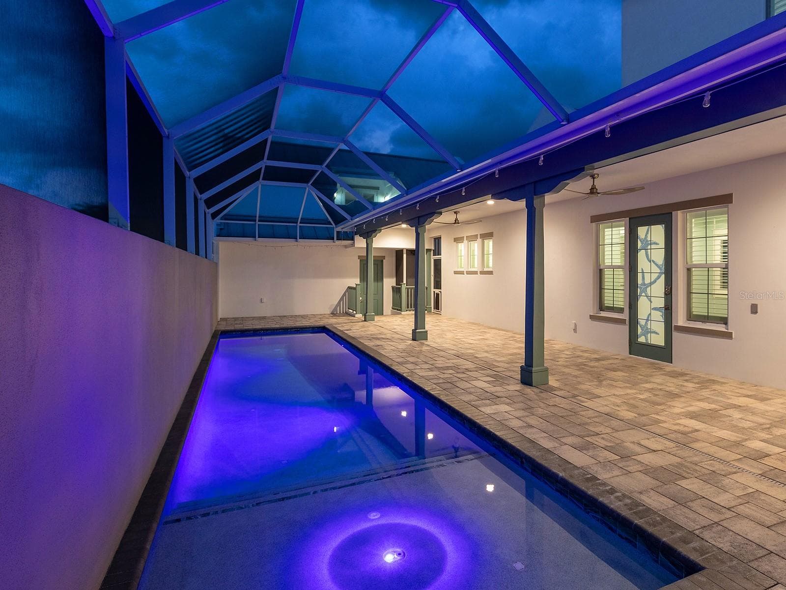 38-foot heated saltwater pool with self-cleaning system, app-controlled lighting, and direct deck access to the ground-floor primary suite - 4024 11TH STREET CT W, PALMETTO