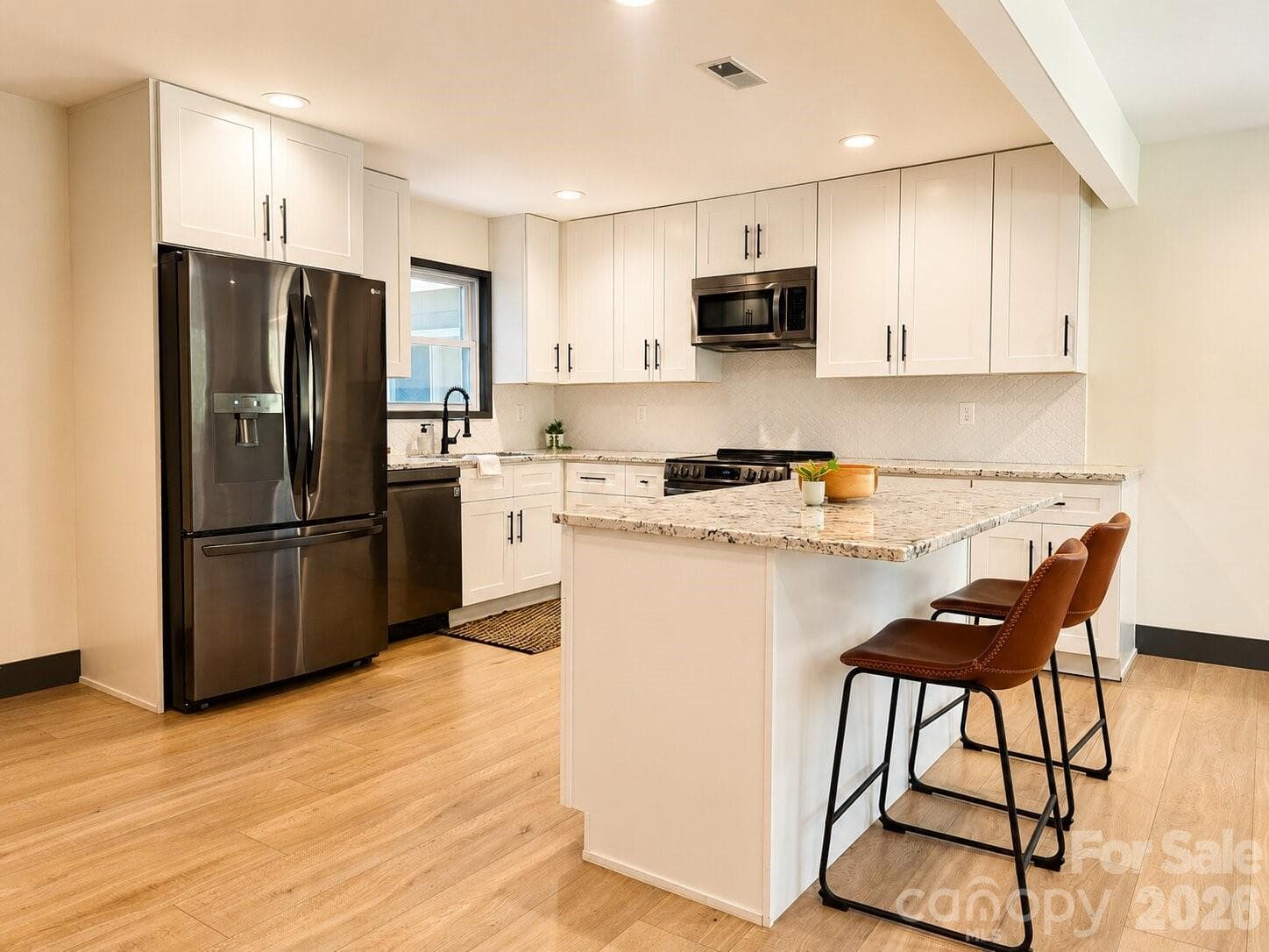 kitchen featuring crisp white cabinetry, granite countertops, stainless steel appliances - Arden