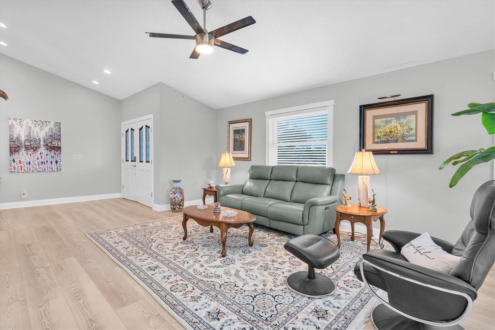 Spacious and light-filled living room with high ceilings, offering a warm and inviting setting for relaxing or entertaining. - 6501 MOCKINGBIRD WAY S, GULFPORT
