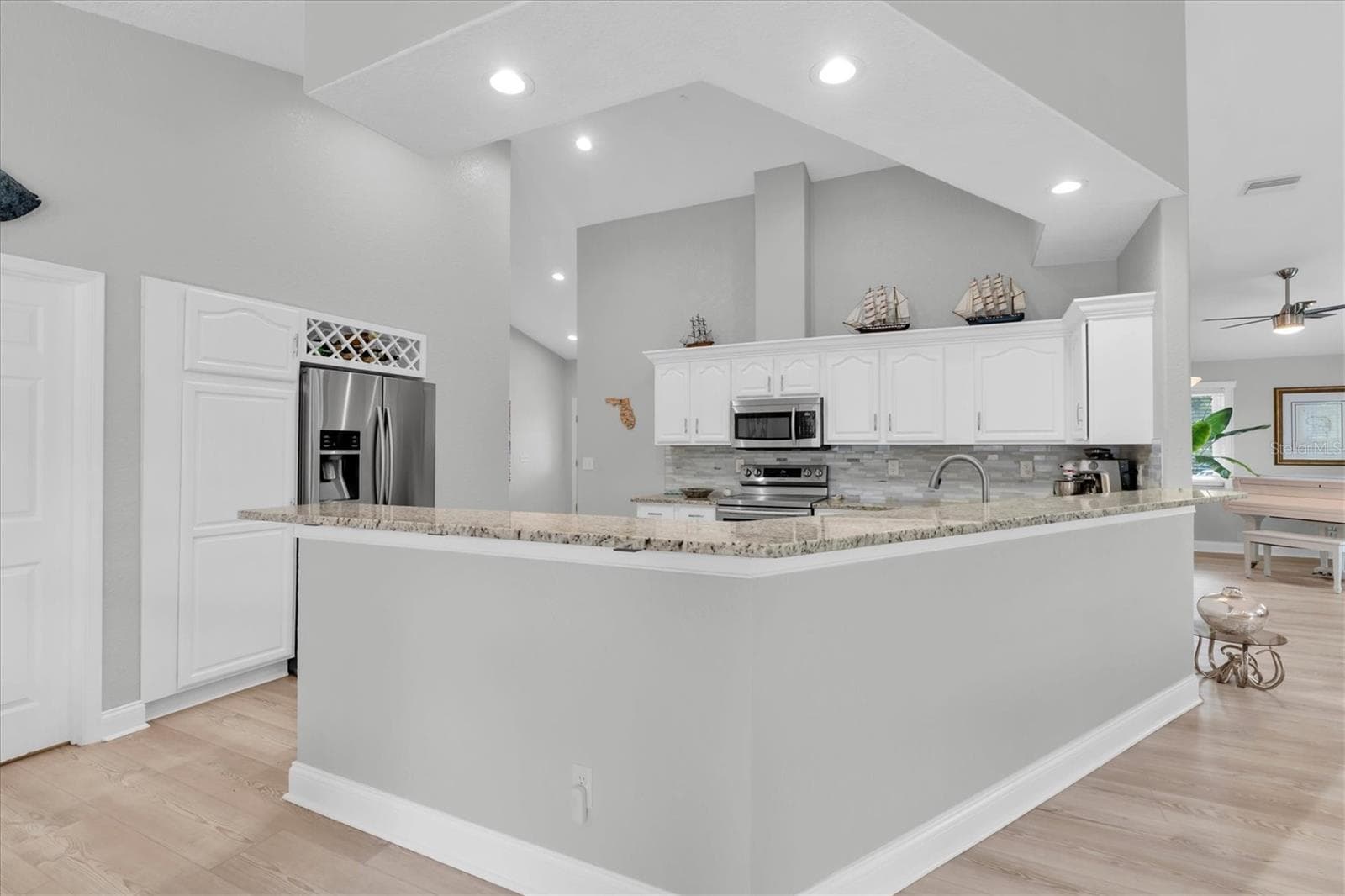 The spacious kitchen overlooks the family room & features a generous granite snack bar, creating a wonderful connection between cooking, casual dining & entertaining. - 6501 MOCKINGBIRD WAY S, GULFPORT