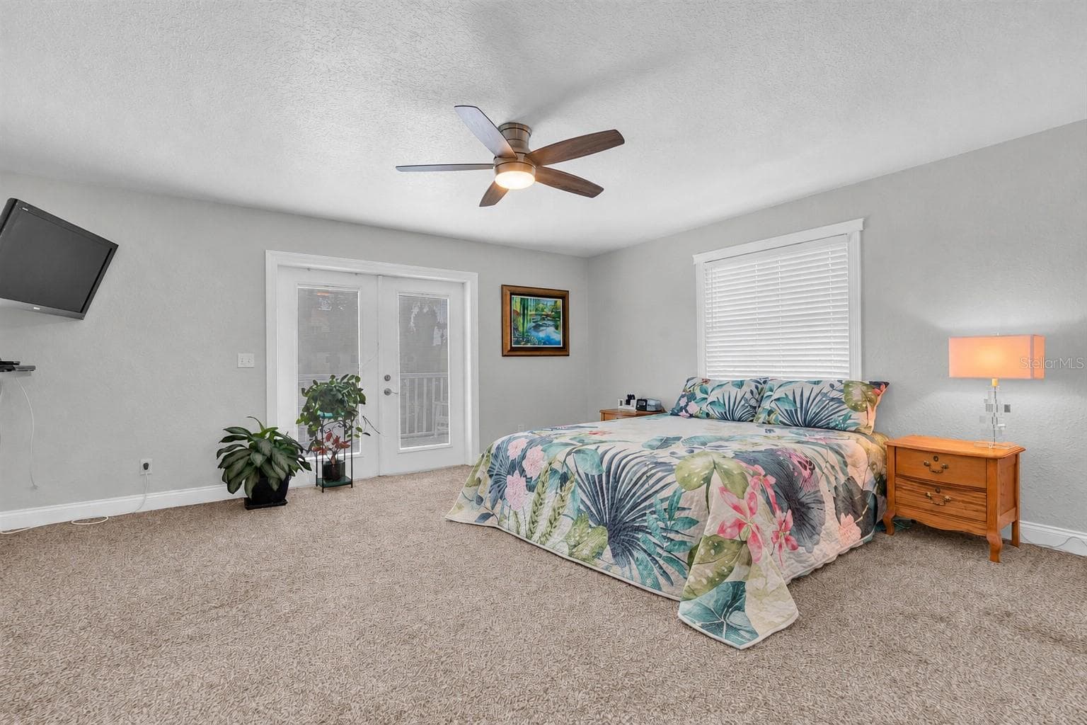The spacious primary suite offers French doors opening to the rear deck, a private ensuite bath & a generous walk in closet; creating a comfortable & relaxing retreat. - 6501 MOCKINGBIRD WAY S, GULFPORT