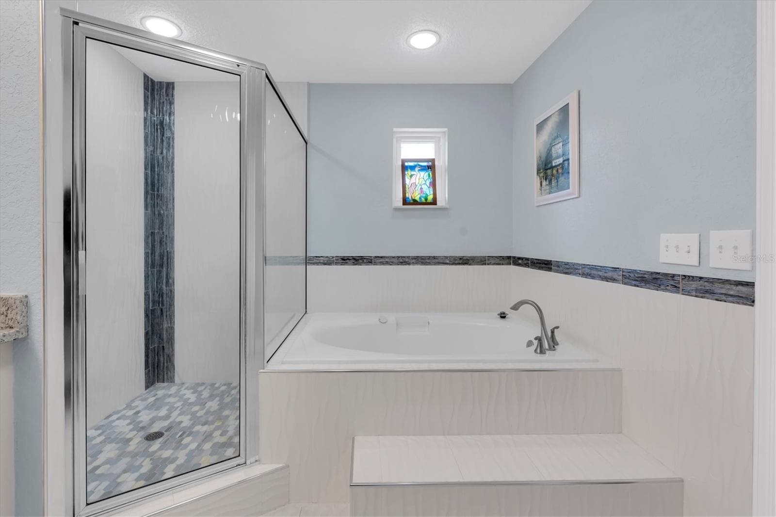 The primary ensuite bath features a deep jetted soaking tub, creating a relaxing, spa like retreat in the comfort of home. - 6501 MOCKINGBIRD WAY S, GULFPORT