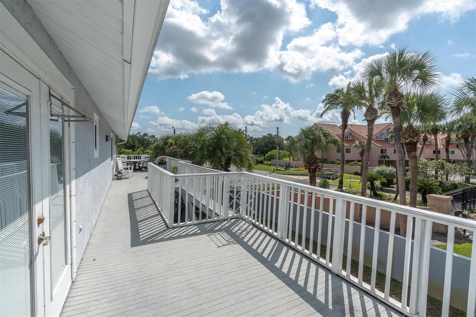 Enjoy beautiful views from the second story deck, conveniently accessible from both the primary suite & the kitchen/family room areas; perfect for relaxing or entertaining outdoors. - 6501 MOCKINGBIRD WAY S, GULFPORT