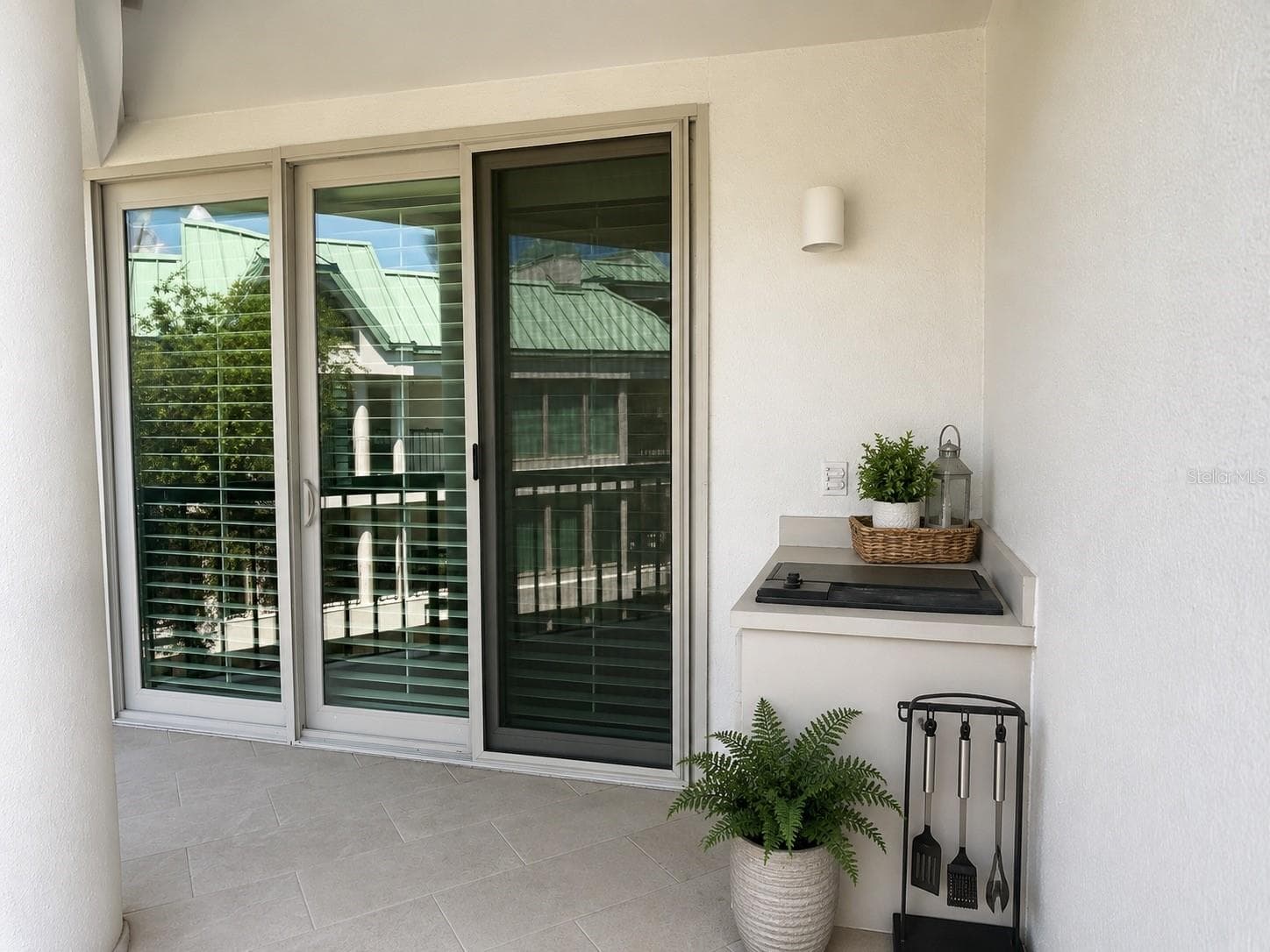 Grill area on wraparound first-level balcony. Sliding glass doors leading to 1st floor primary bedroom in background. - 947 SEDDON COVE WAY #947, TAMPA