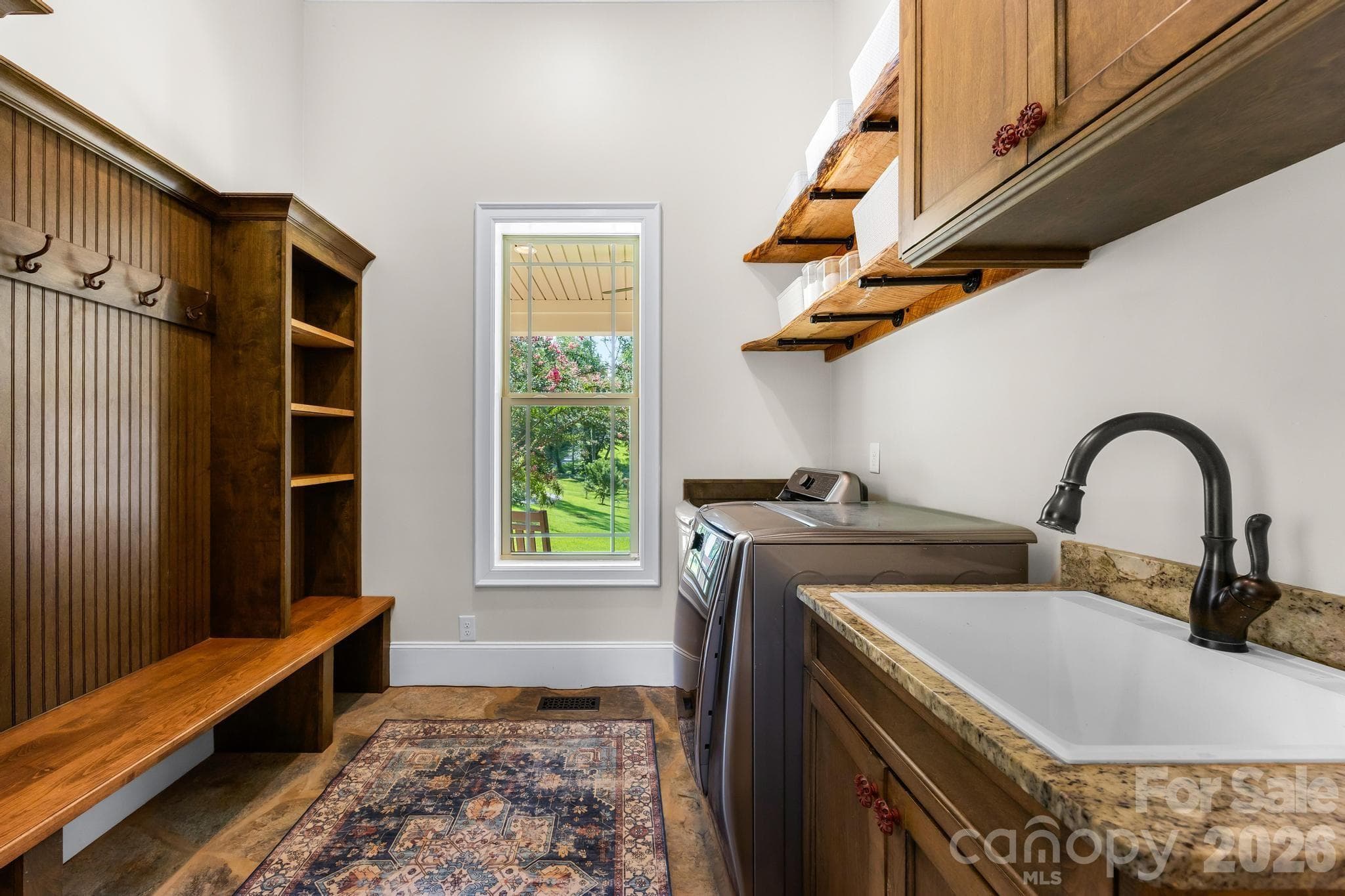 Mudroom -stone flooring, built in cabinets/shelving/bench, sink, and washer/dryer - 6334 Long Island Road, Catawba