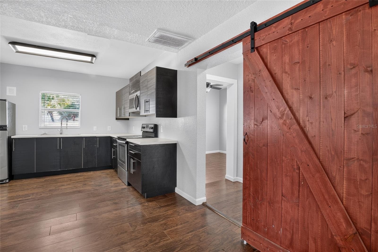 barn doors to bedroom 1 - 4104 ORANGE AVE SE, HIGHLAND CITY