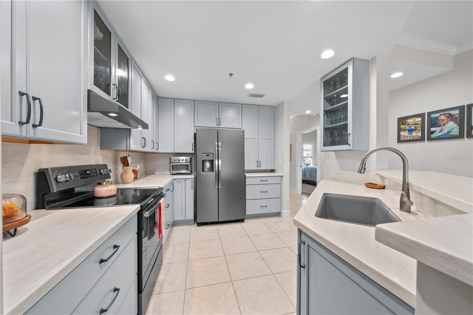 Kitchen features showcase cabinets, quartz countertops and stainless appliances. - 13570 MYSTIC DR #102, SEBASTIAN
