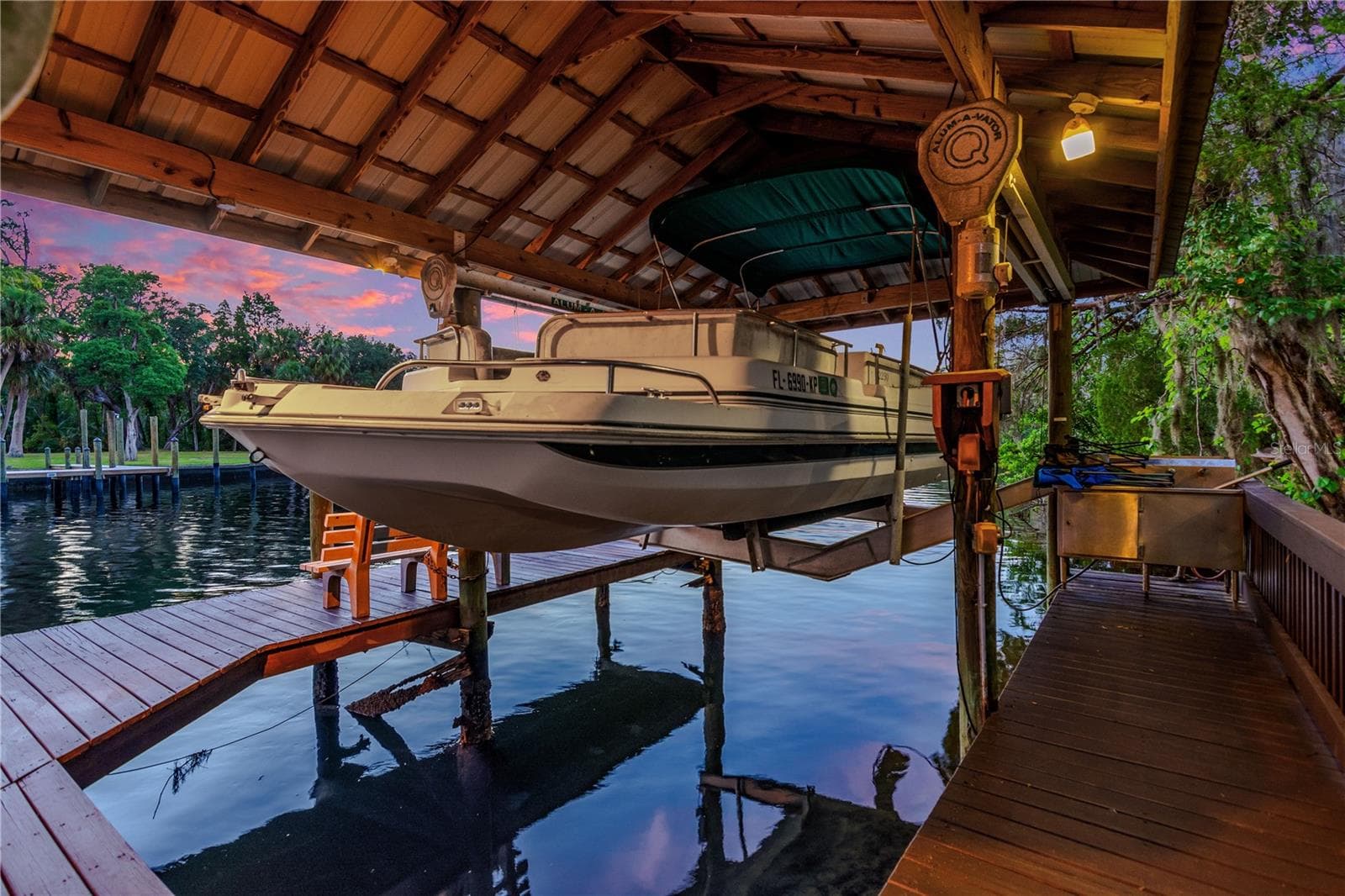 Private covered boat lift and dock provide convenient water access directly from the property—perfect for enjoying boating, fishing, kayaking, and everything the Alafia River lifestyle has to offer. - 11526 RIVER COUNTRY DR, RIVERVIEW