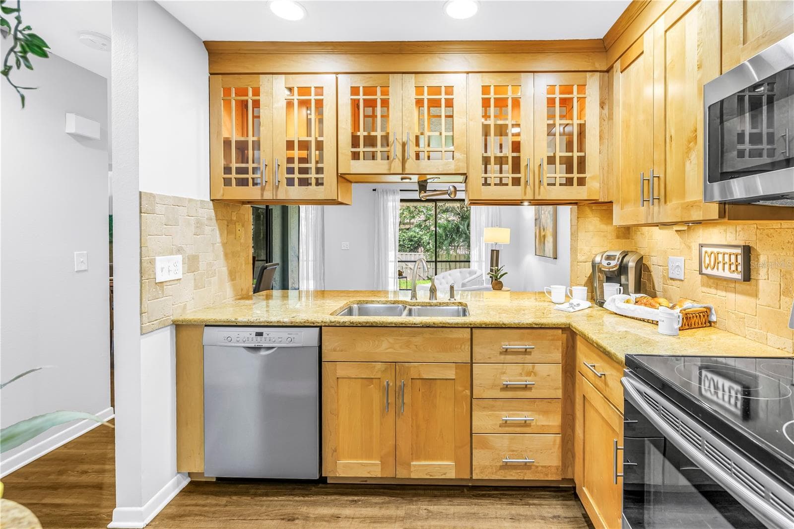 Great Kitchen workspace with glass cabinets for Natural light.  Granite Counters and stainless appliances - 1092 SANABEL CT NE, ST PETERSBURG