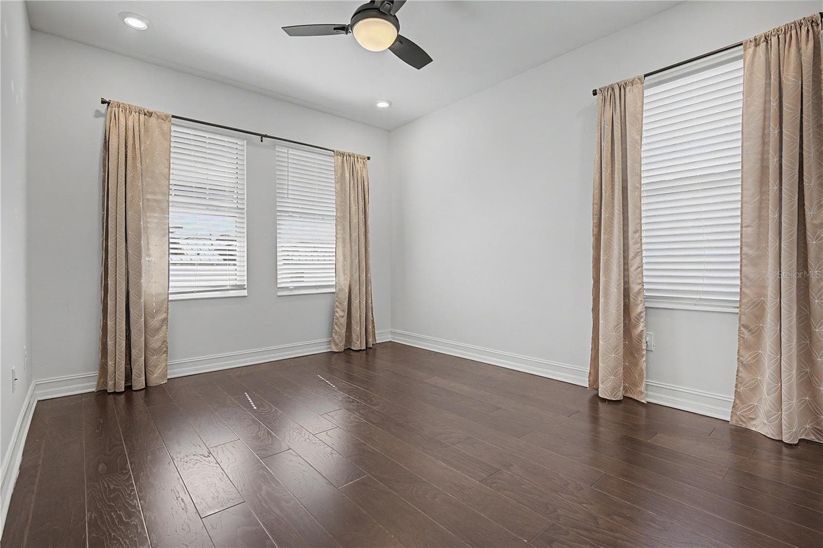 Third-level third bedroom featuring east- and south-facing windows for abundant natural light. - 5351 BRIDGE ST #38, TAMPA