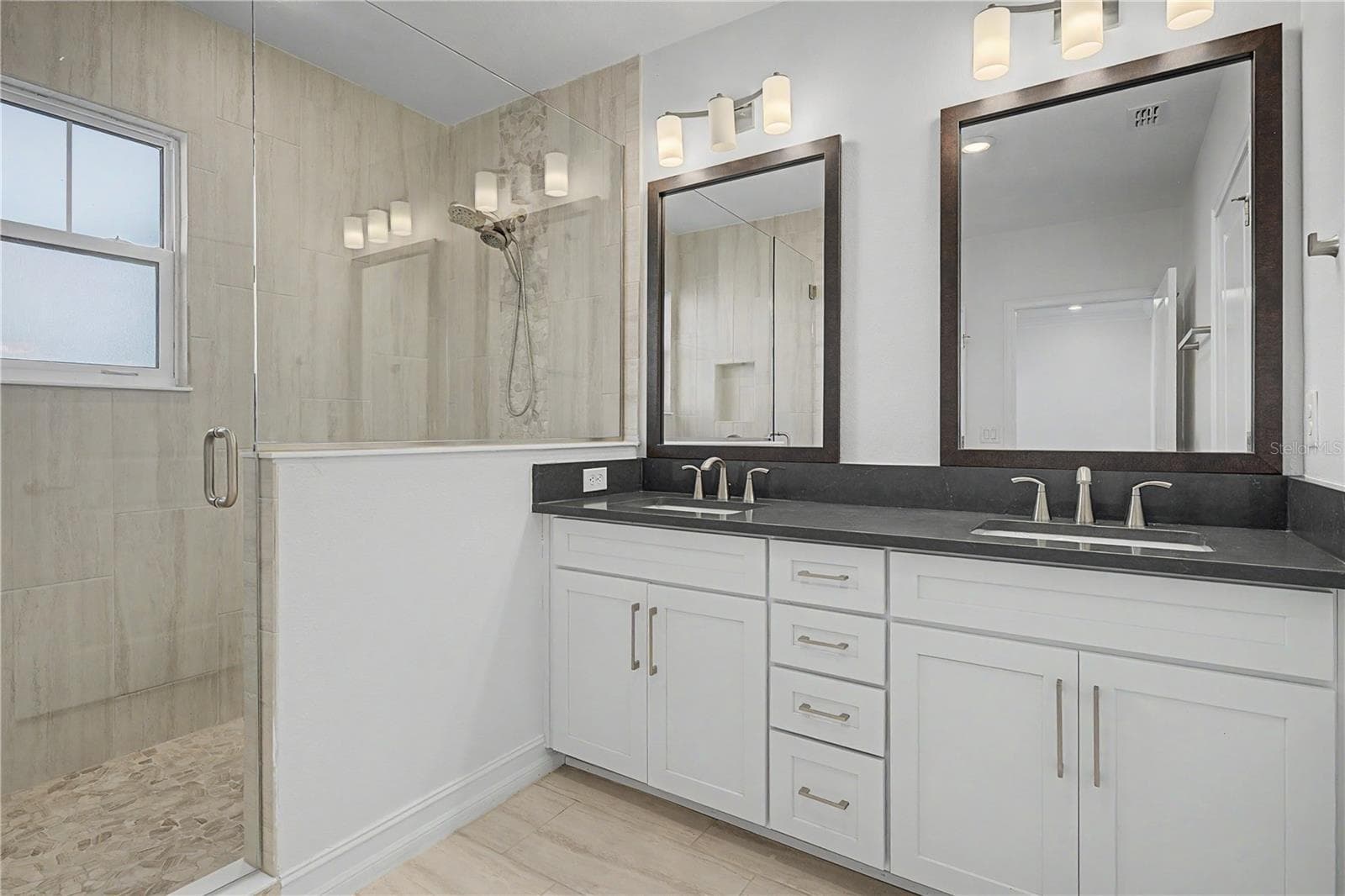 Third-level primary en-suite featuring double sinks and a spacious walk-in shower. - 5351 BRIDGE ST #38, TAMPA