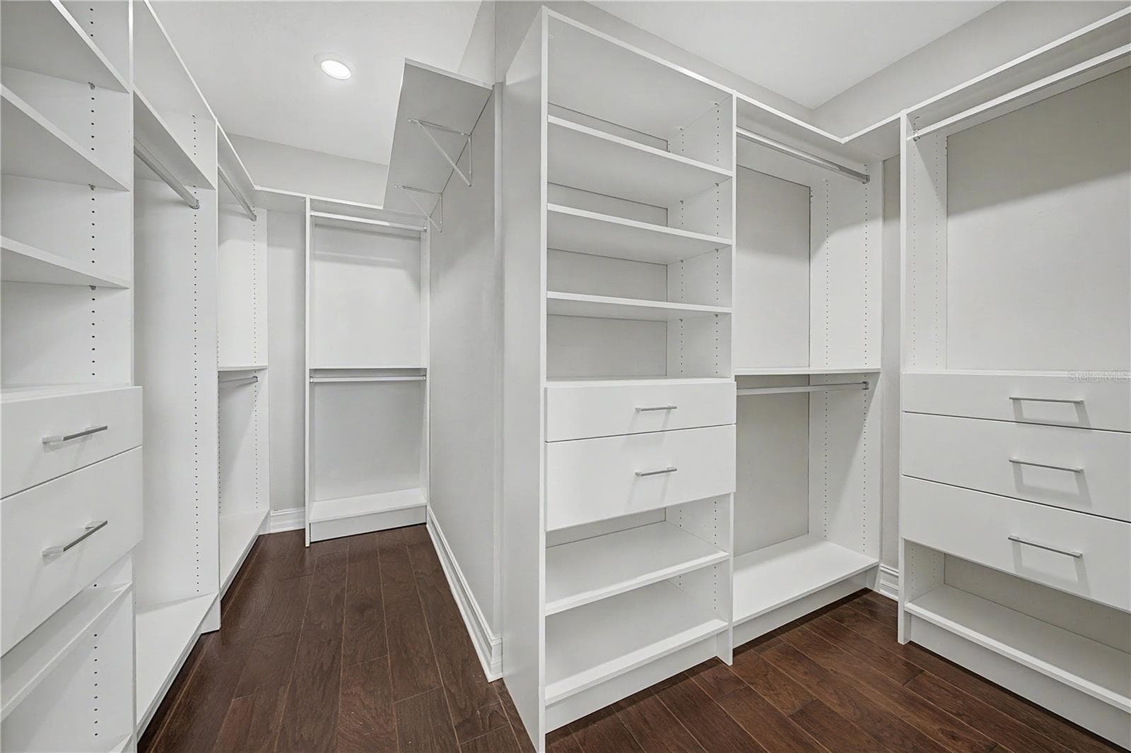 Spacious primary suite closet featuring professional custom built-in cabinetry and shelving.Spacious master closet featuring custom built-in cabinetry and shelving. - 5351 BRIDGE ST #38, TAMPA