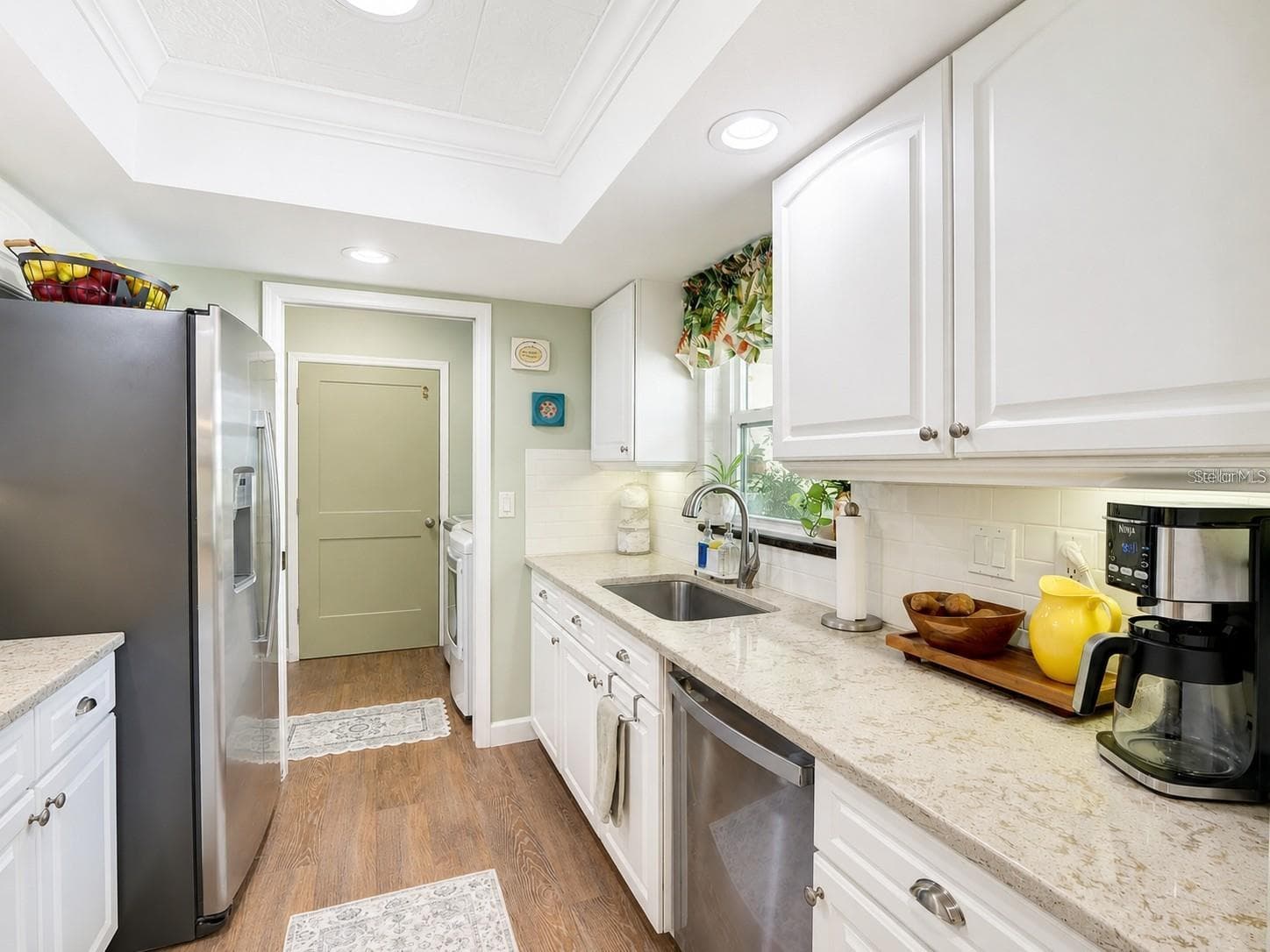 Kitchen: Pocket Door to the Pantry, W/D, & Garage Entry - 100 S TREMAIN ST #G2, MOUNT DORA