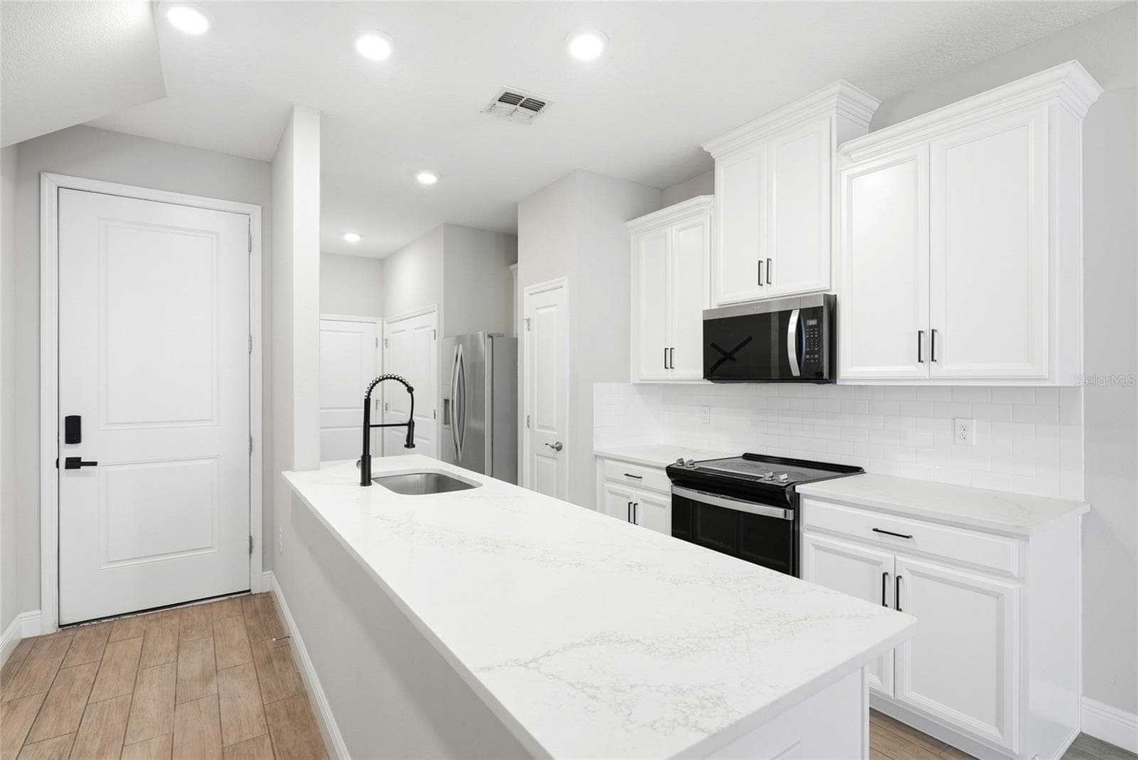 Kitchen with quartz countertops and front door entry area - 5282 NEIL DR, ST PETERSBURG
