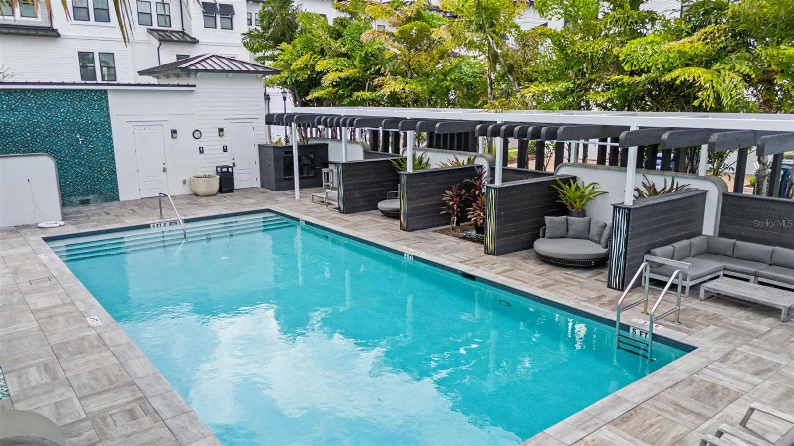 Crystal-blue community pool with plenty of inviting spaces to relax and unwind. - 5351 BRIDGE ST #38, TAMPA