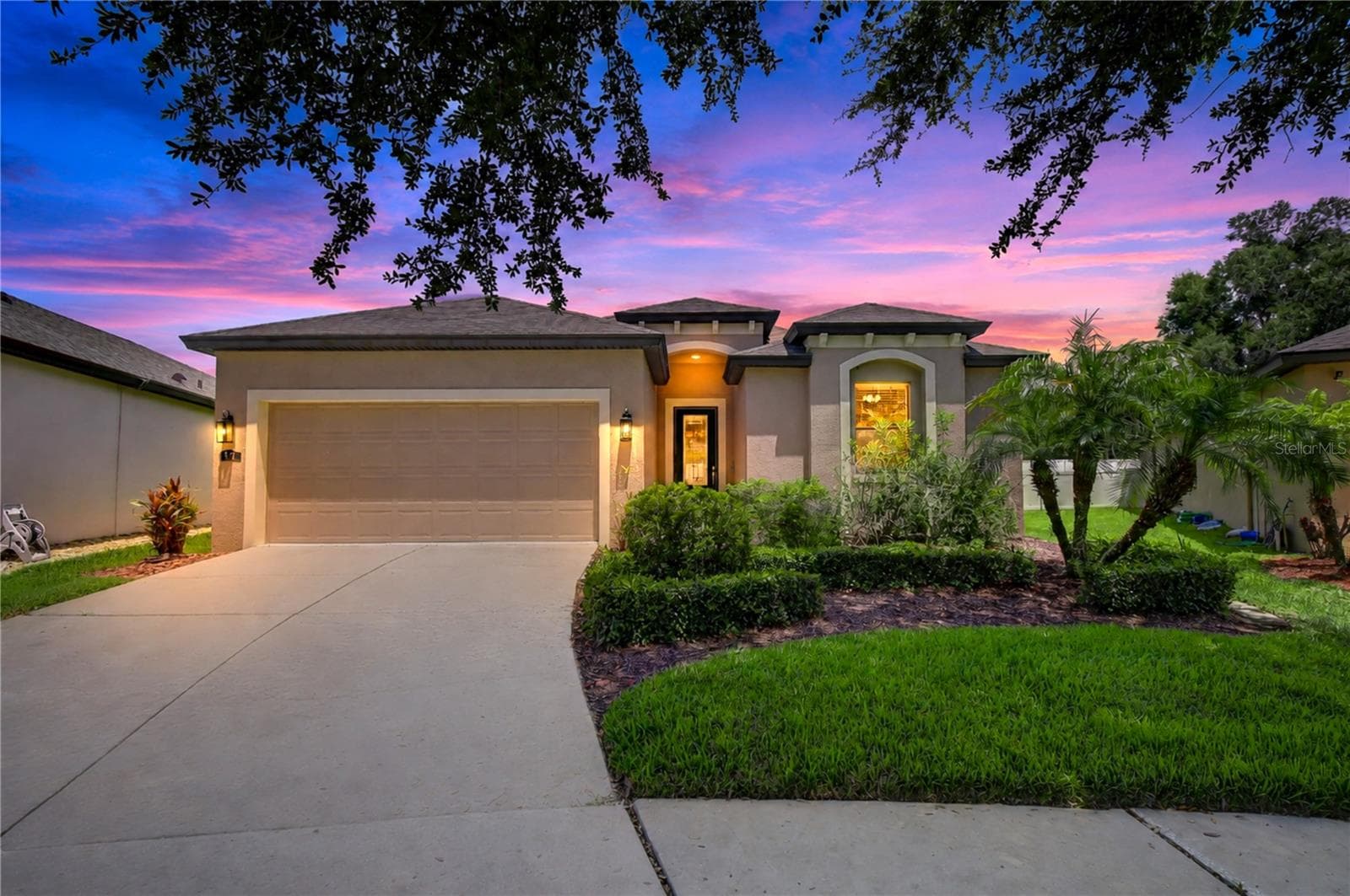 Dramatic twilight exterior featuring warm lighting and inviting curb appeal. - 826 VINO VERDE CIR, BRANDON