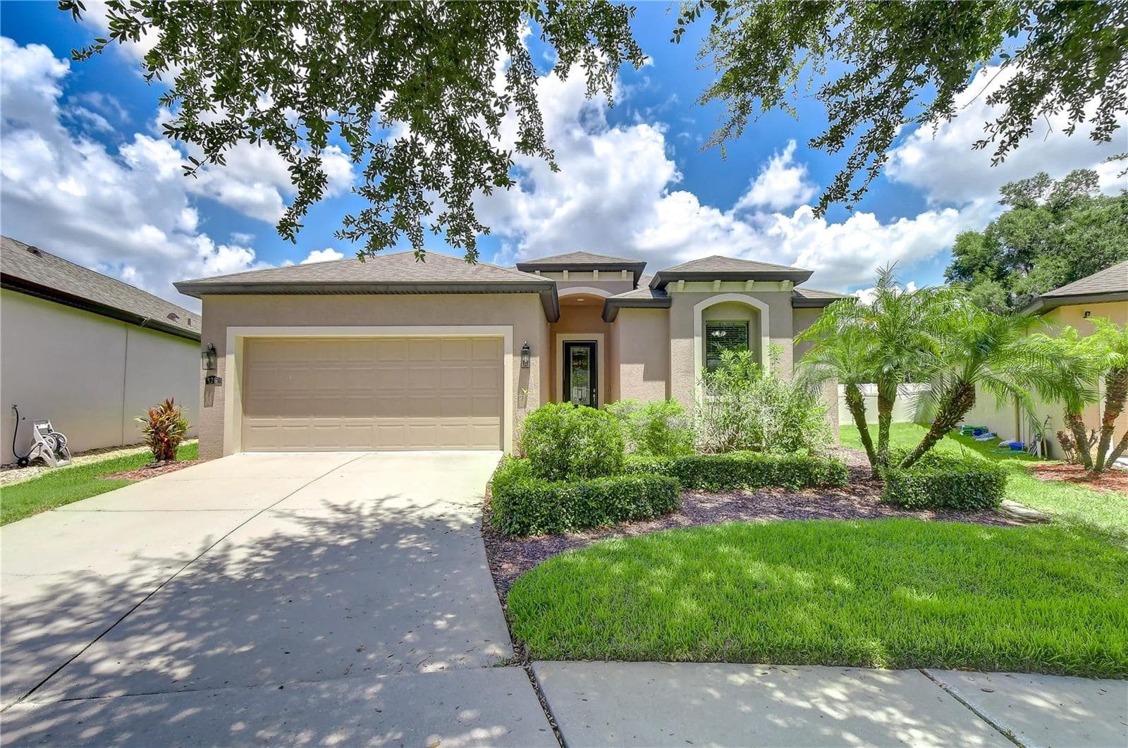 Front exterior featuring stone accents and broad driveway approach. - 826 VINO VERDE CIR, BRANDON